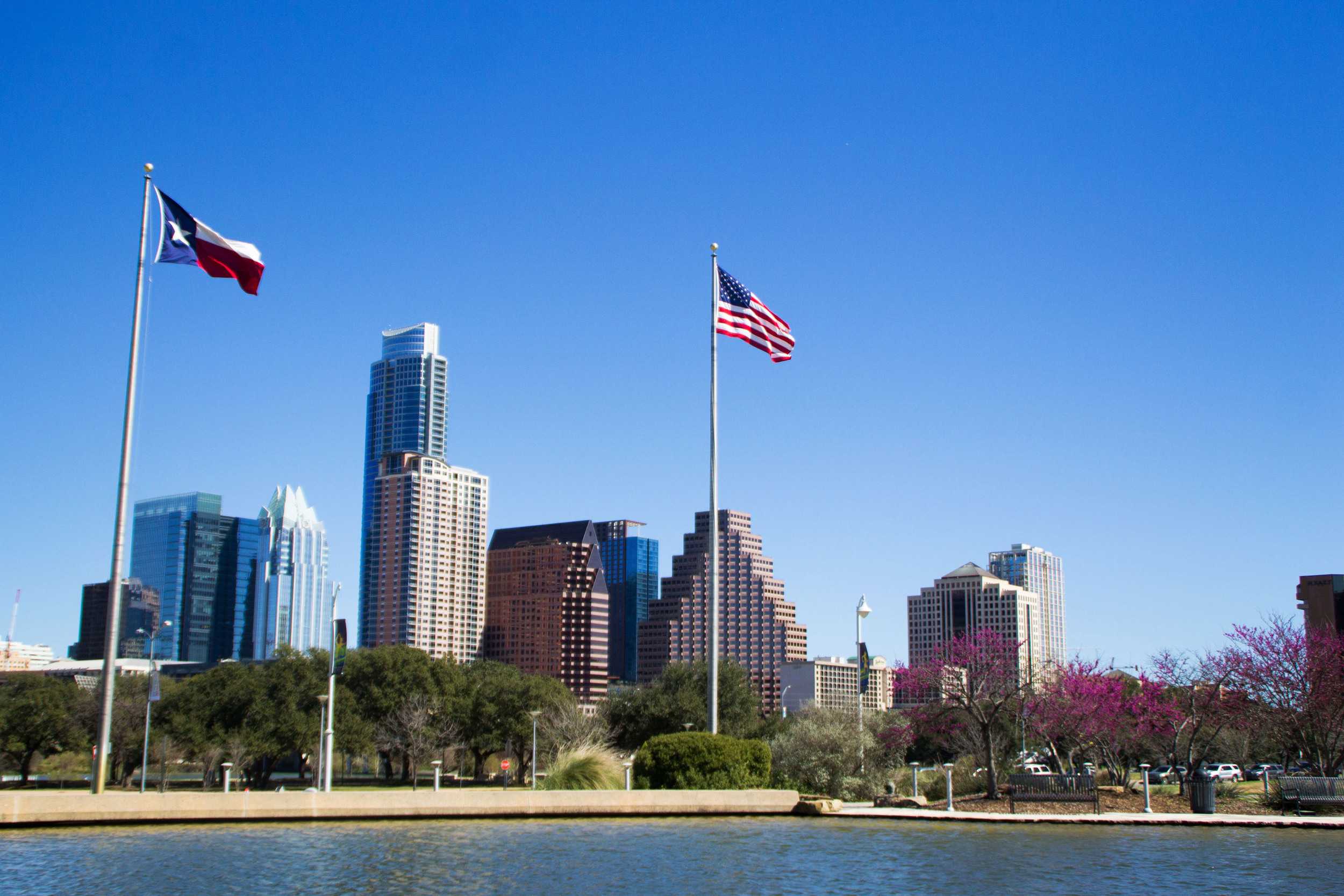  The warm spring wind blows as the Texas and United States flags frame the downtown Austin skyline, as seen from the Long Center. 