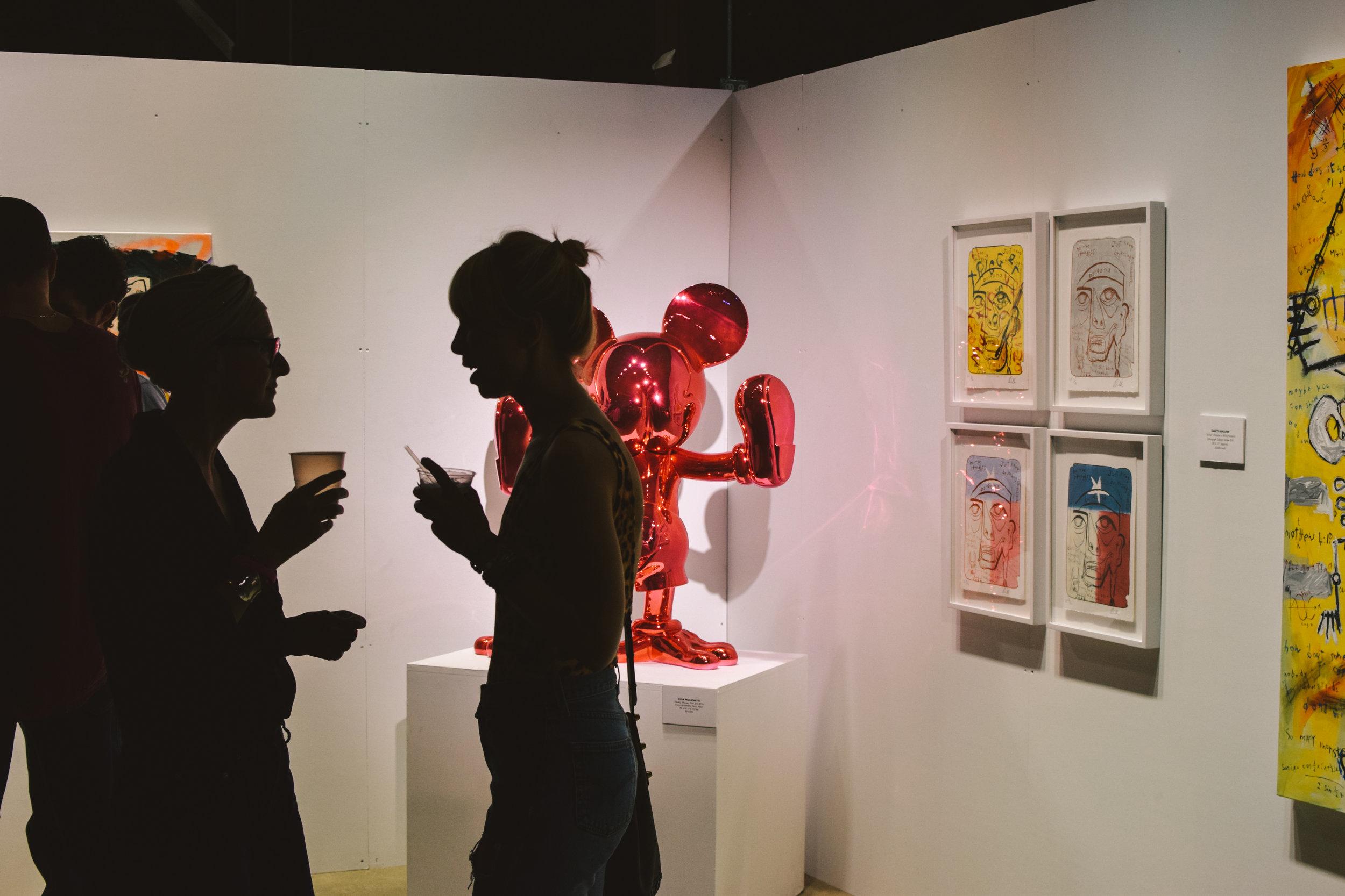   Attendees chat in front of Fidia Falaschetti's "Freaky Mouse."  