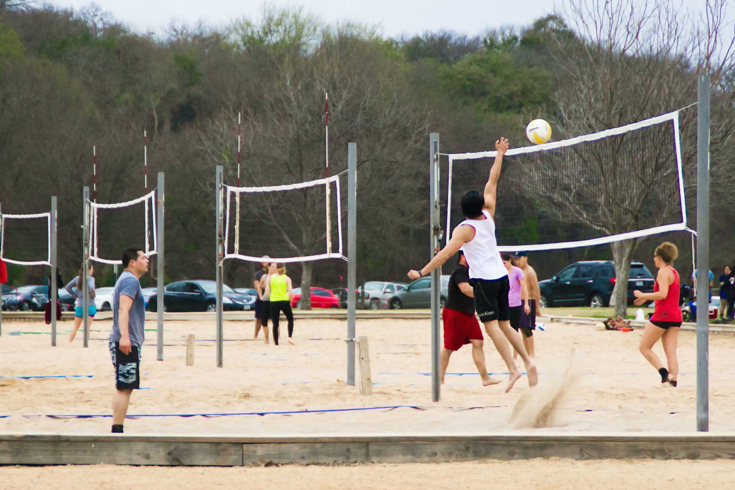  A man jumps up to hit a volleyball during a casual game at Zilker Park. 