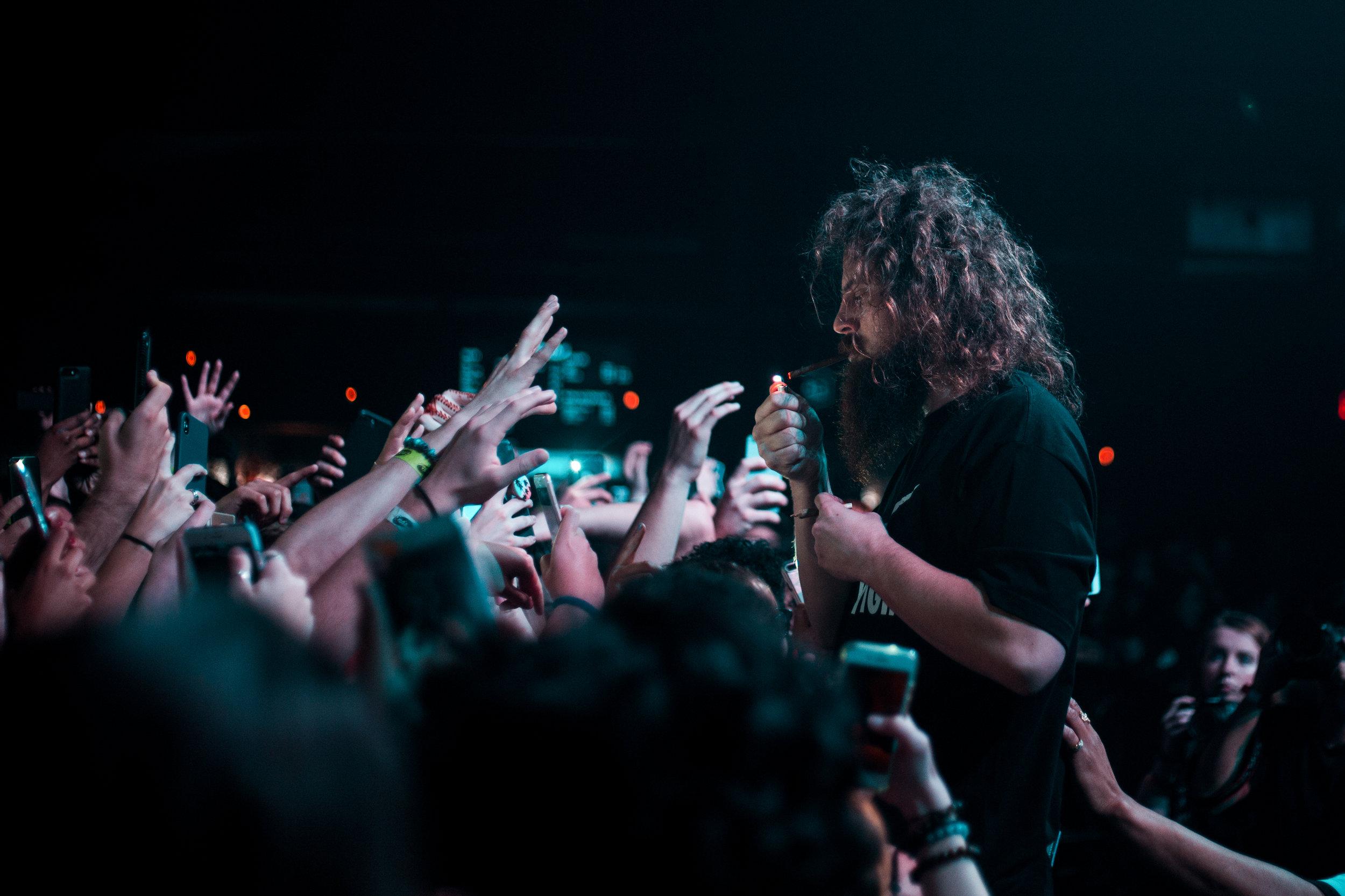   Hippie Sabotage member Kevin lights a cigarette in between songs.   