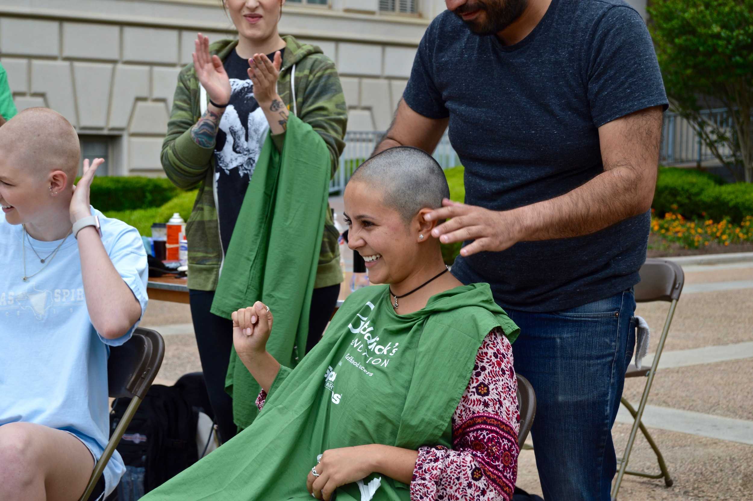   Bonilla looks up and smiles as the barber finishes up her new haircut.   