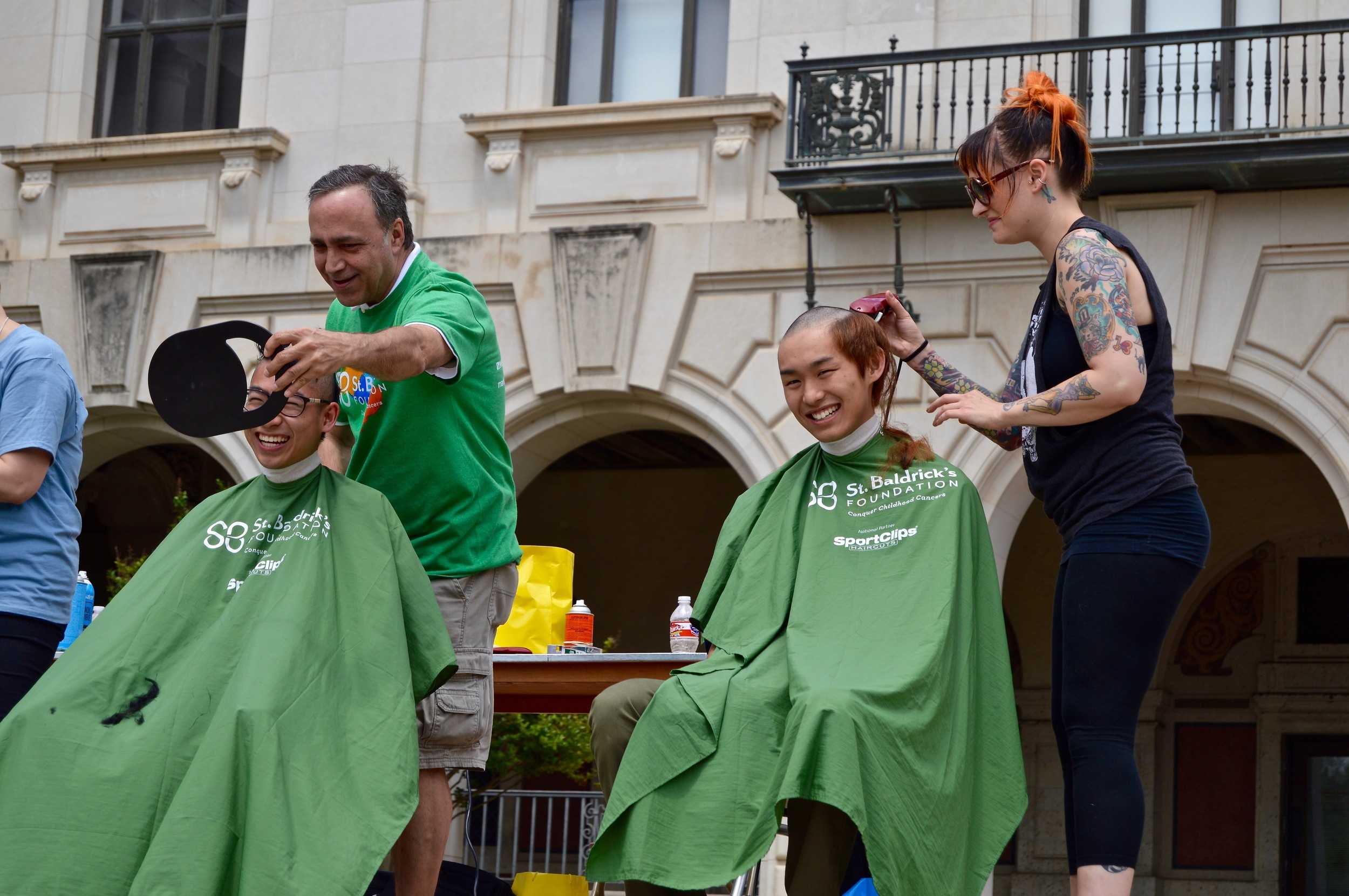   Brave the Shave participants smile and laugh as their hair is shaven off.  