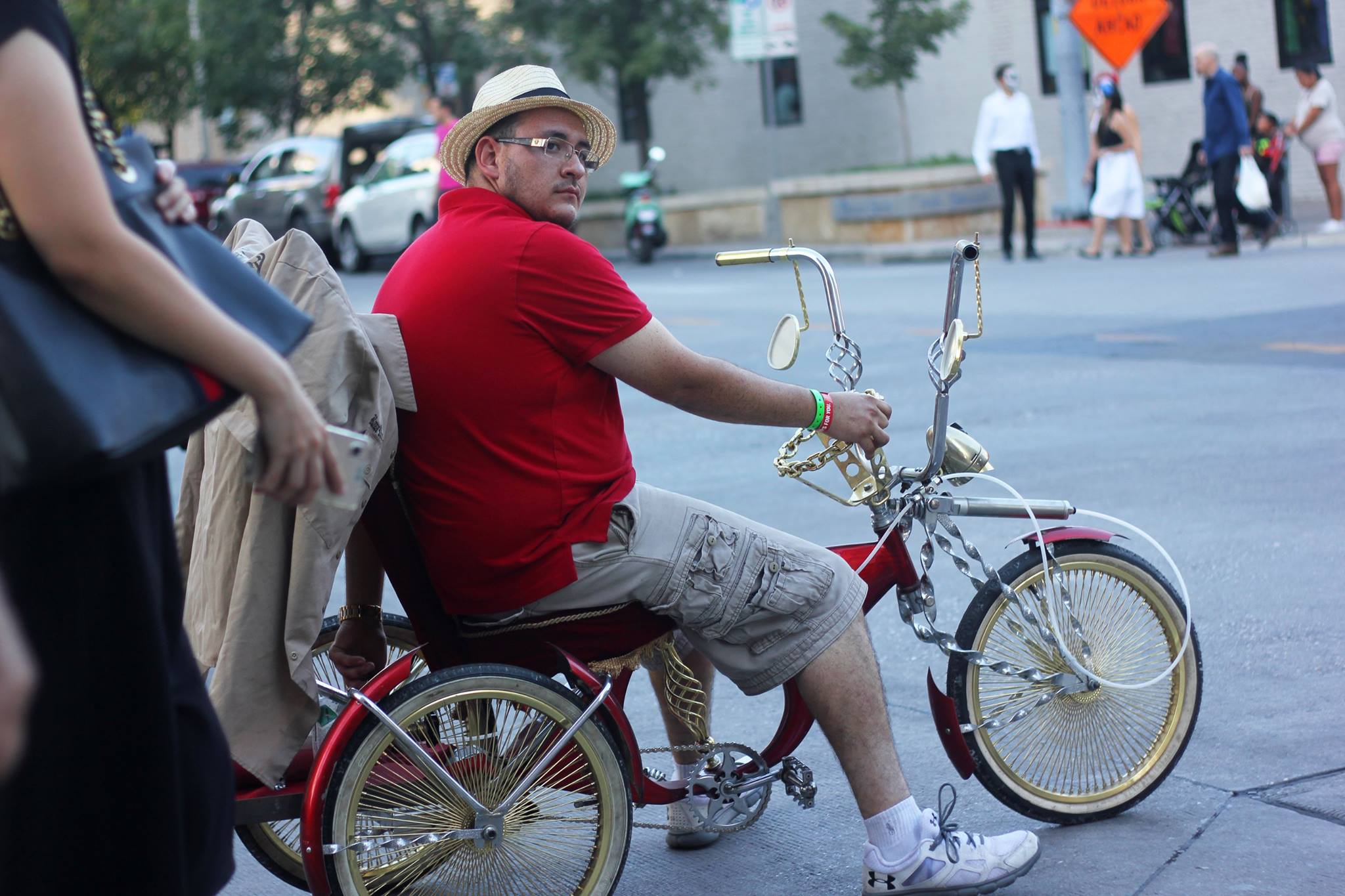   Man rides his low-rider bicycle from one end of the festival grounds to the other.   