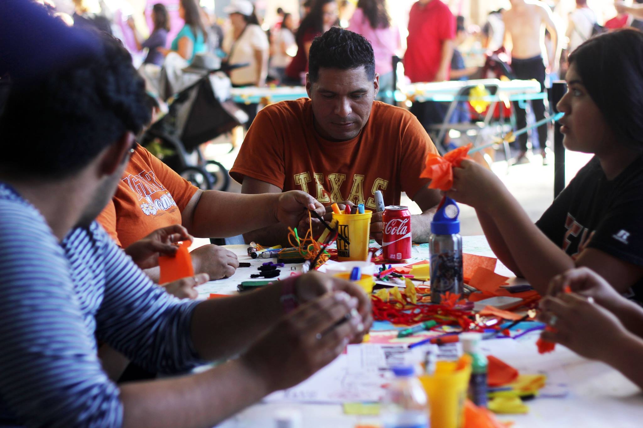   Family participates in art activities such as coloring calaveras and making floral head pieces.   