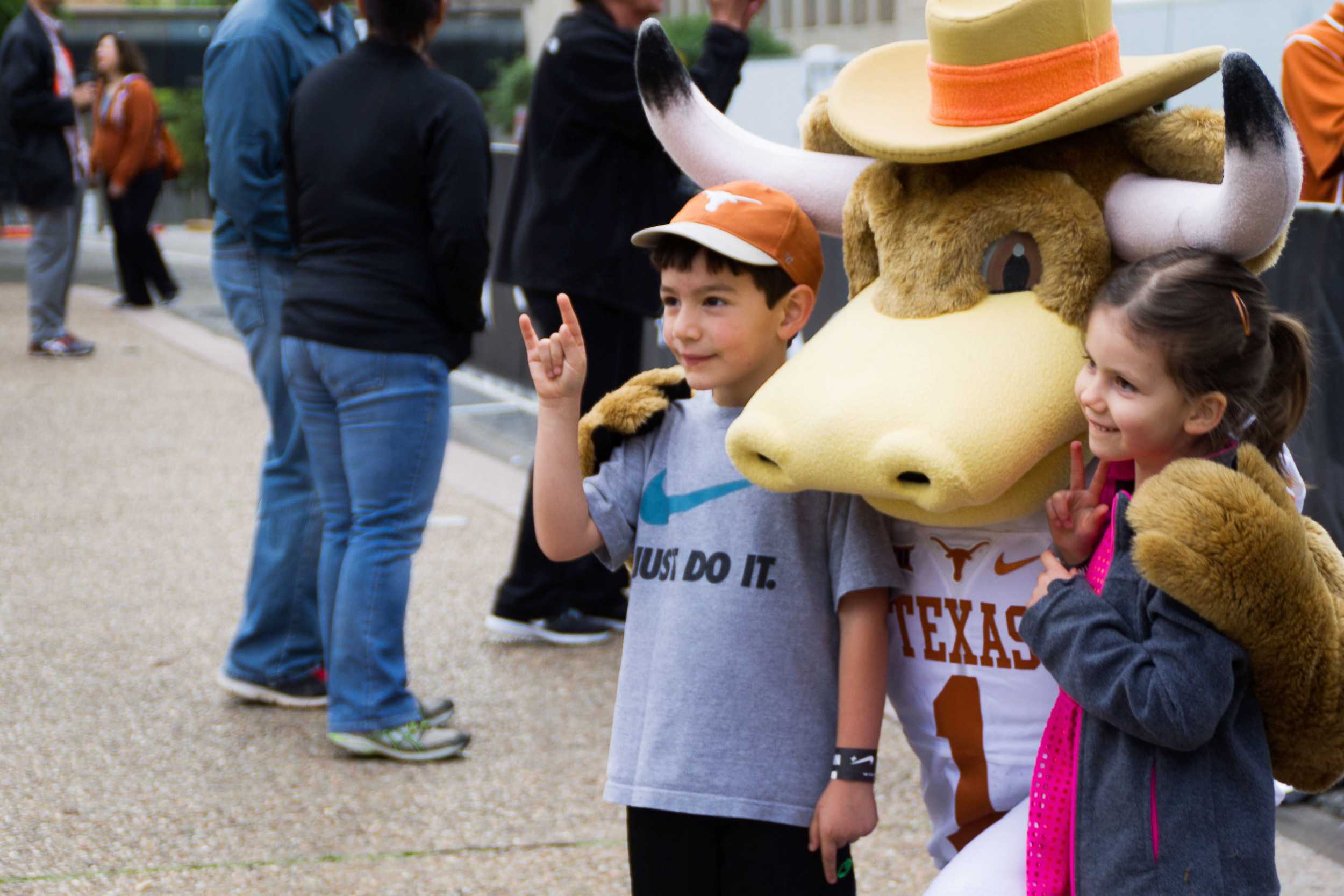  Little longhorns get a bear-hug from Bevo at the sideline of the starting line. 