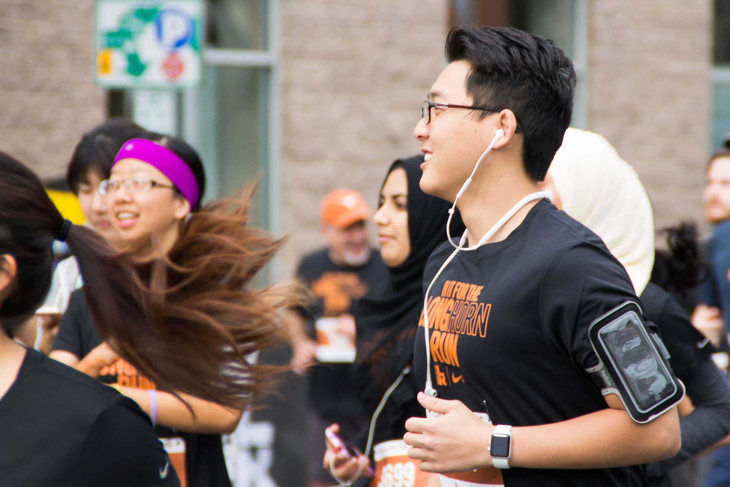  A cheerful participant jogs along just after the cannon blows, signaling the beginning of the 5K race. 