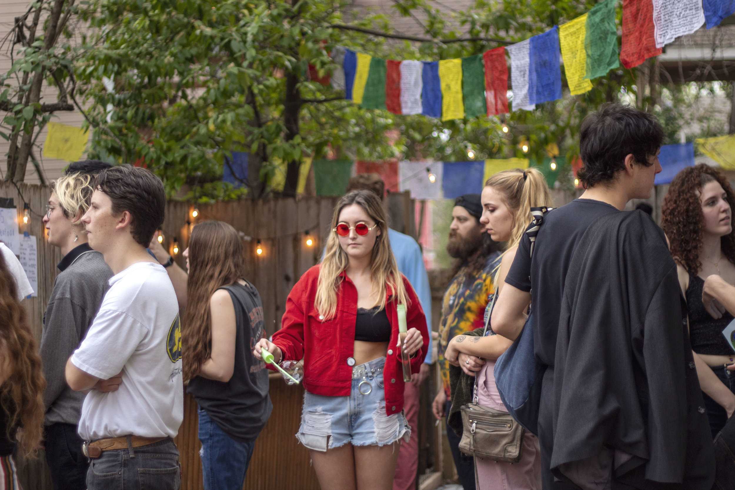   Lauren Gold, Arizona State University student, spends her spring break at PorchFire Fest blowing bubbles with red shades and a matching jacket.  