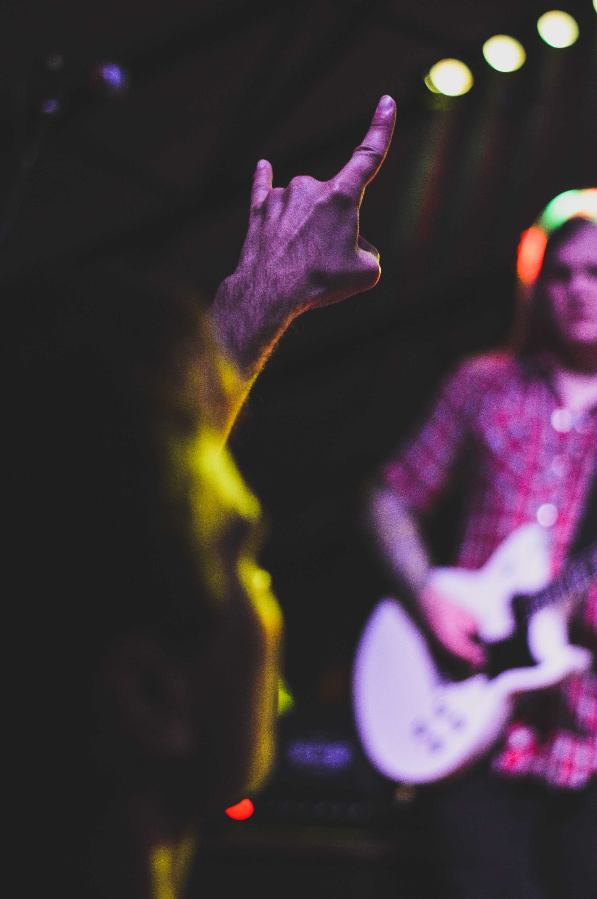   Audience members throw up the sign of the horns in appreciation of the performance.  