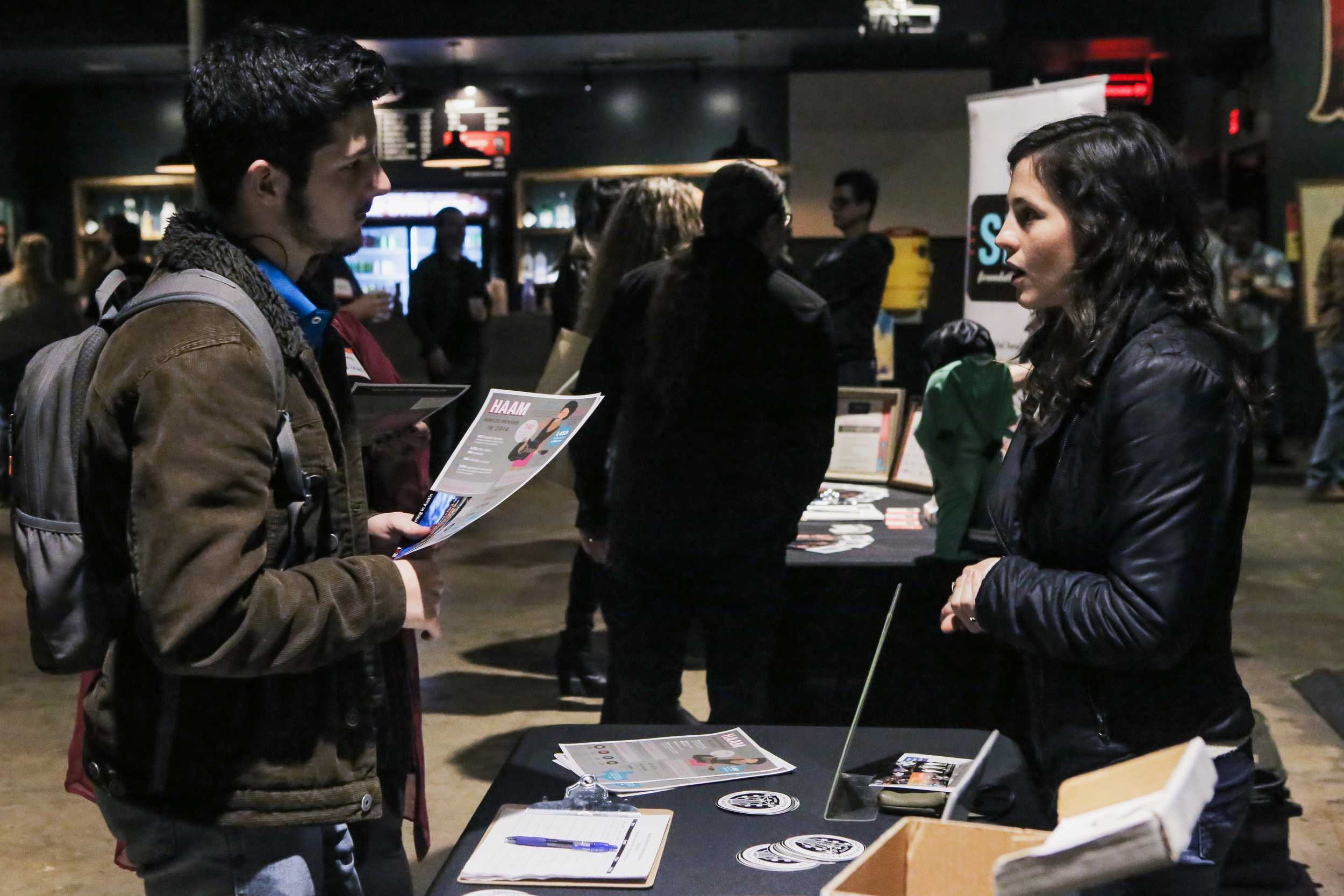   A representative from the Health Alliance for Austin Musicians talks with an expo attendee.     