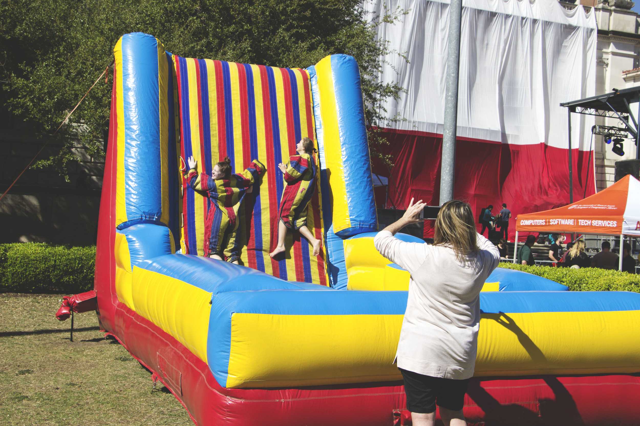   Two UT visitors play at the velcro wall, as their mom takes their photograph.   