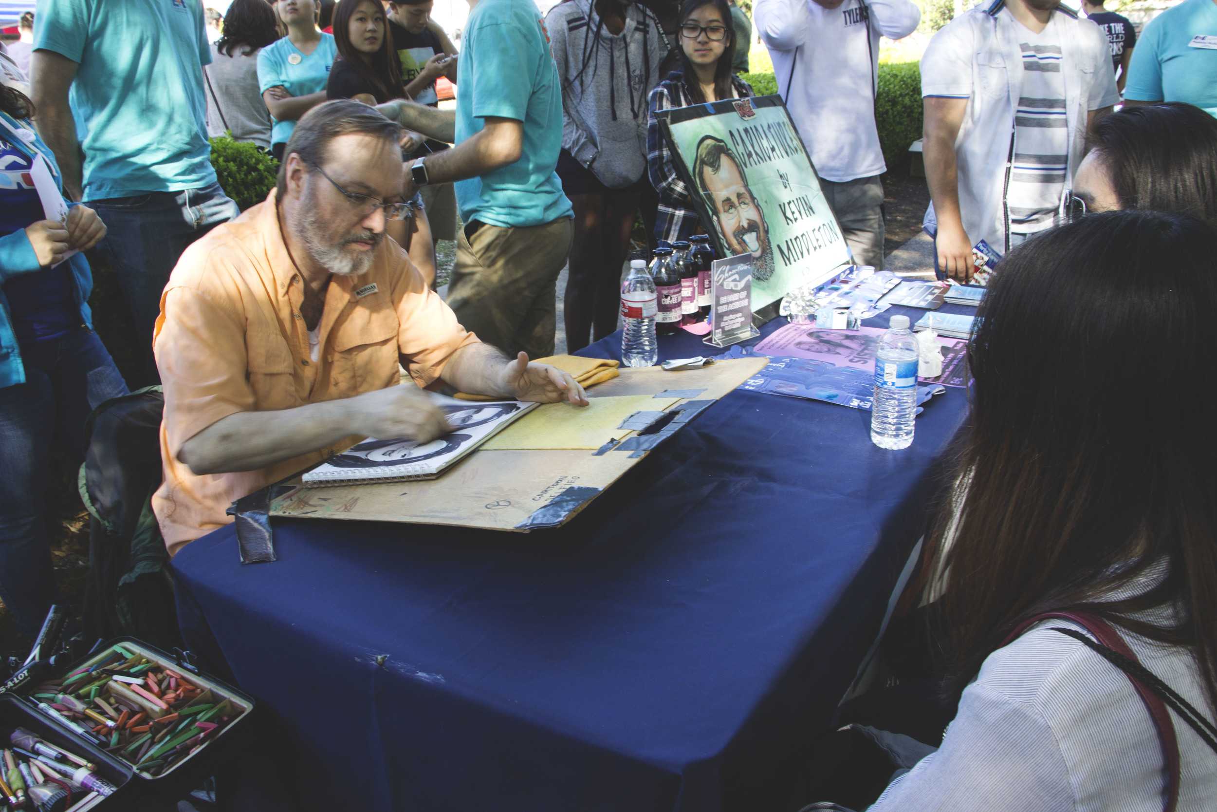   Kevin Middleton draws a free caricature of two students.  