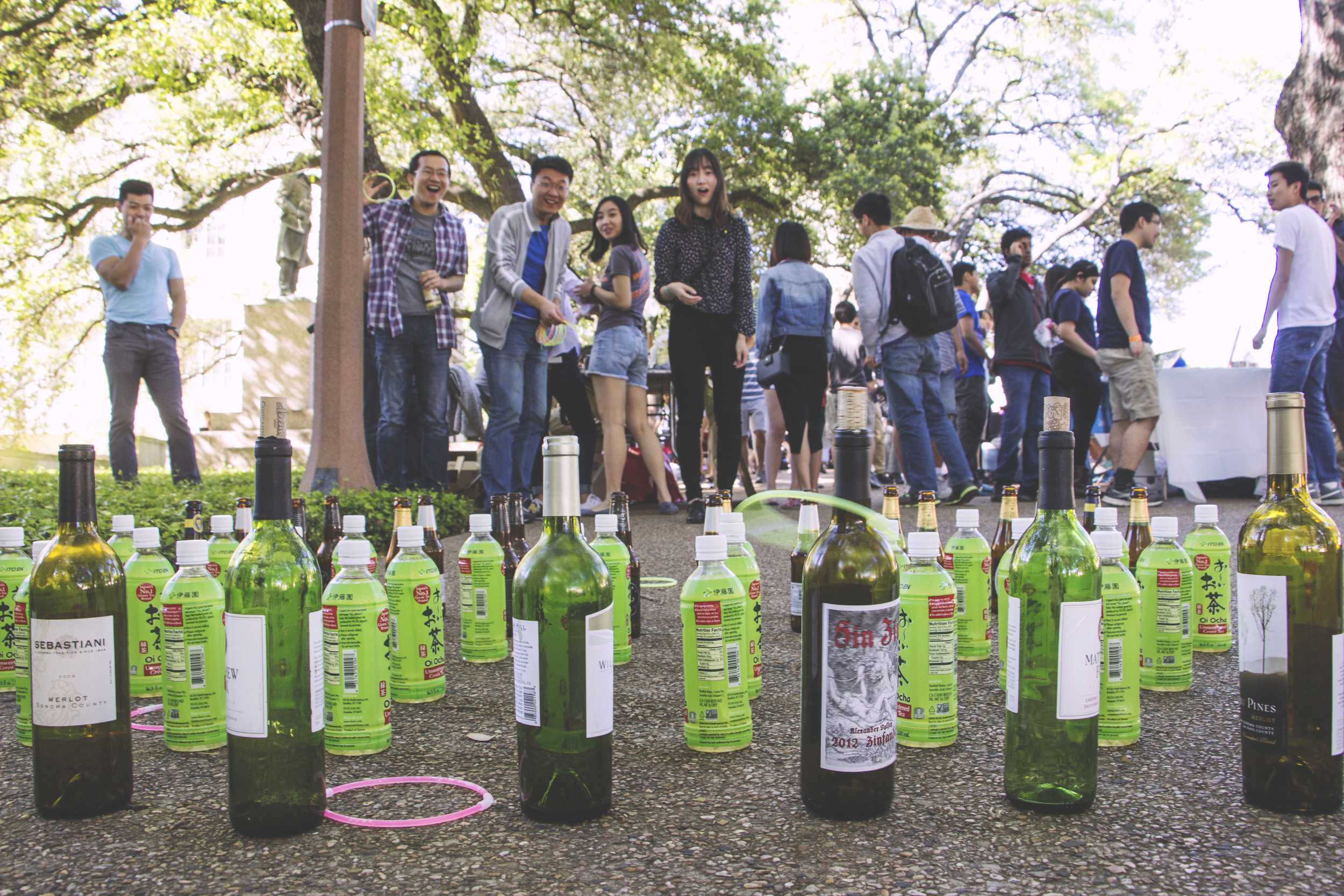   An attendee gets a ring around a bottle while competing in a ring toss game.  