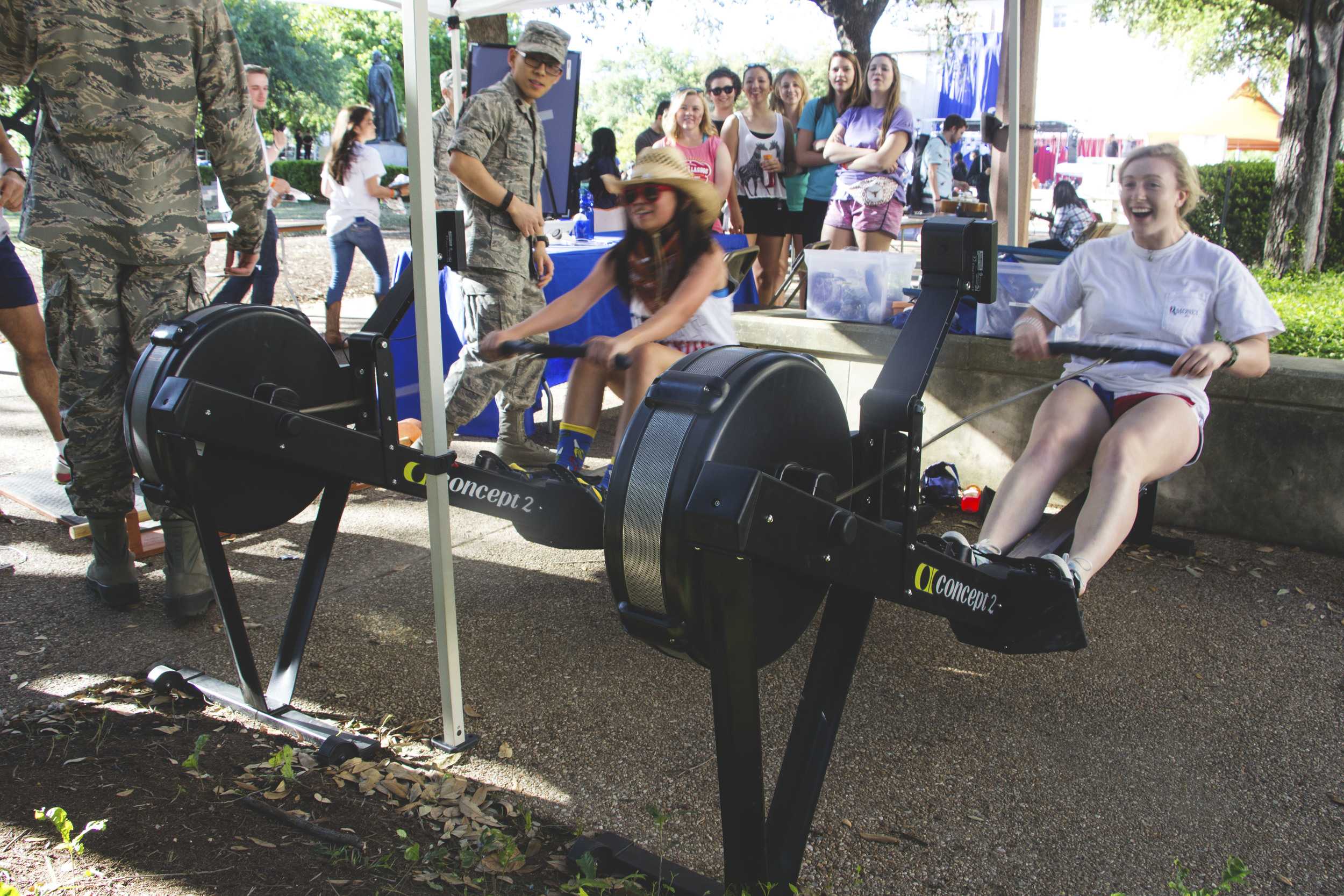   Two attendees compete with one another to get the best ‘rowing’ time.  