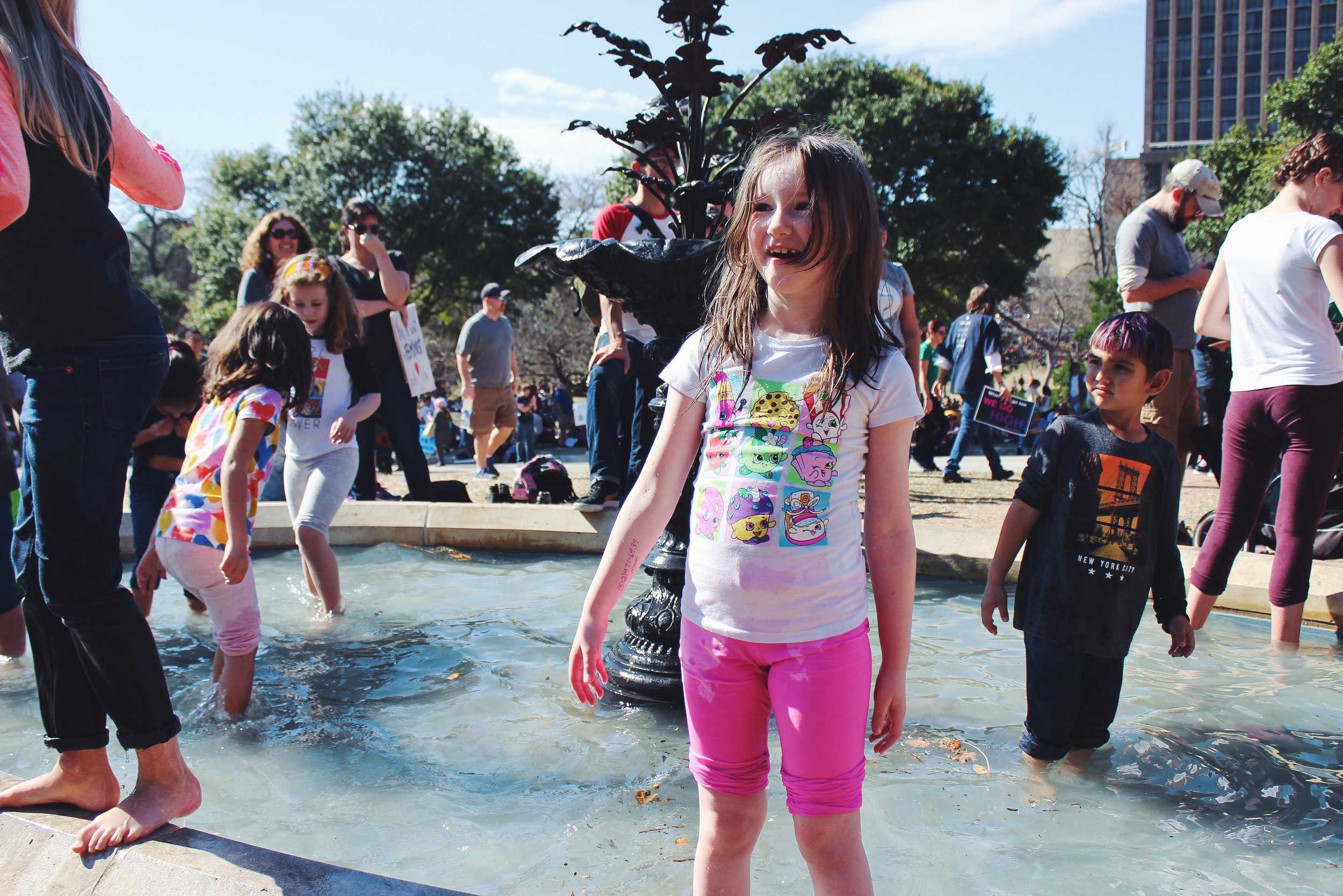   Children splash in the Capitol pond during the speeches.&nbsp;  