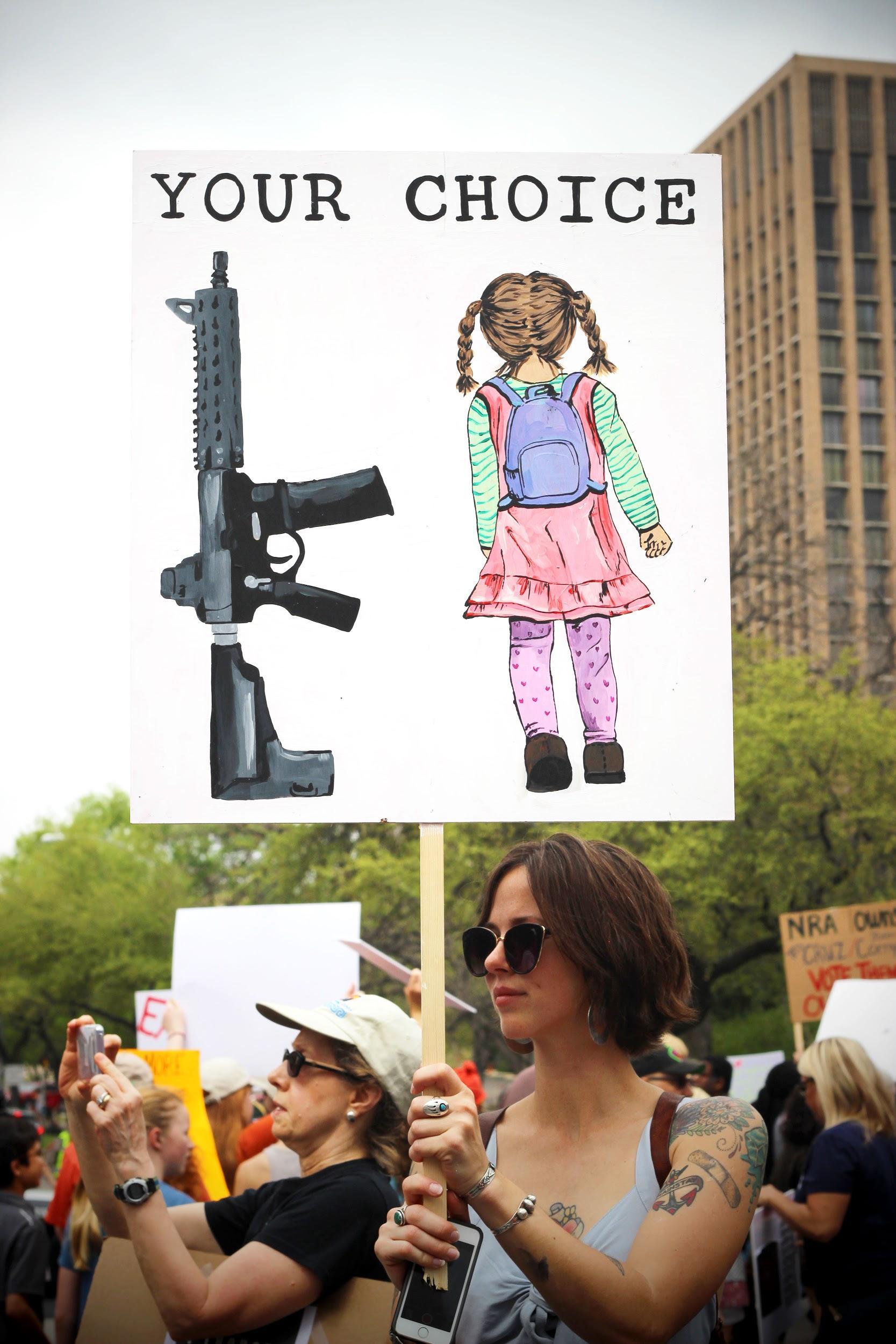   A woman raises her sign up high.  