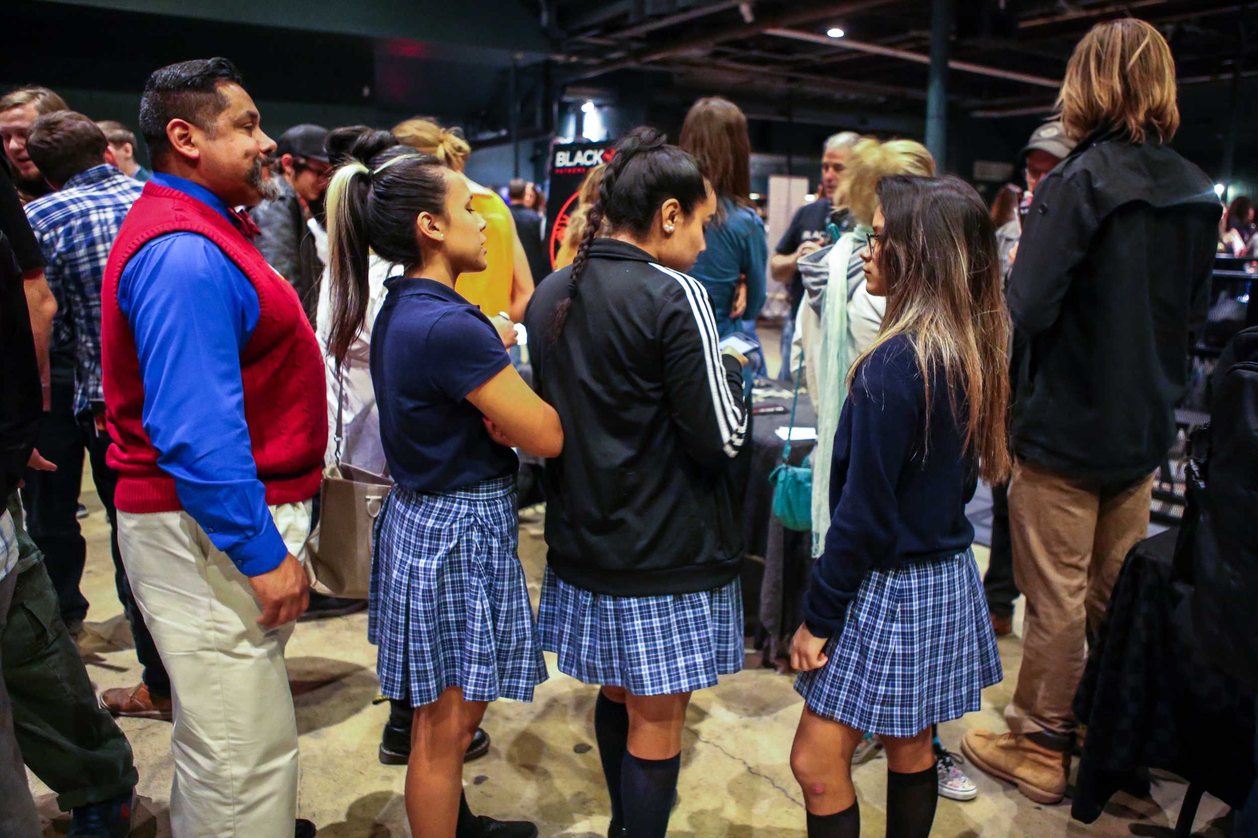   Three girls show off their matching skirts and stand in line to speak to organizations about working in the local Austin music industry.  