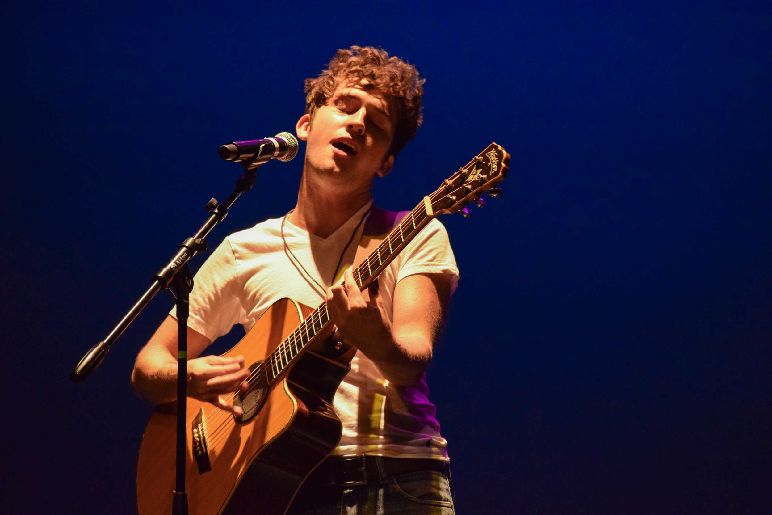   Jefferson Clay, an up-and-coming singer/songwriter, croons one of his original songs into the mic.  