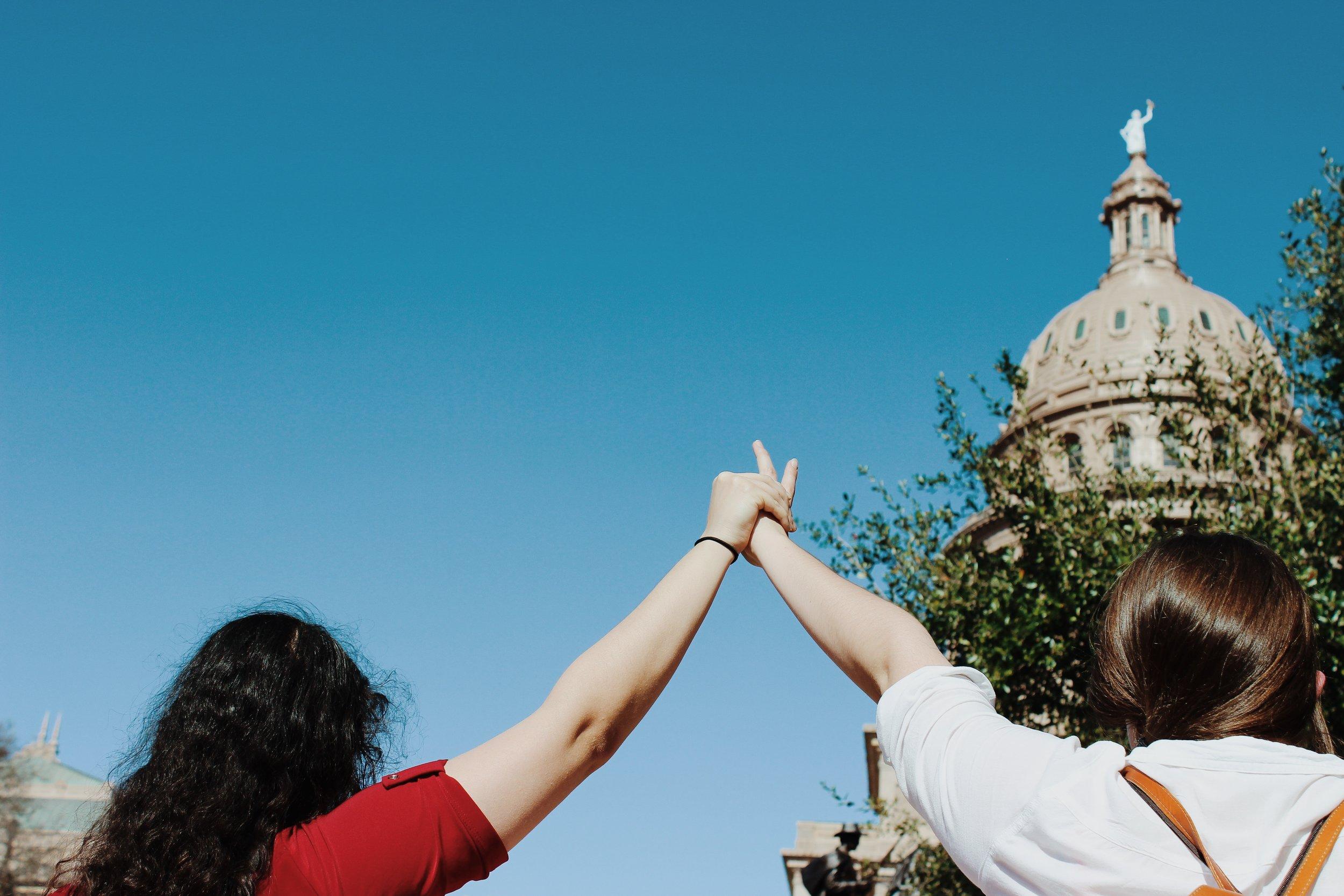   Two women join hands as the first legally married same-sex couple of Texas speak.     