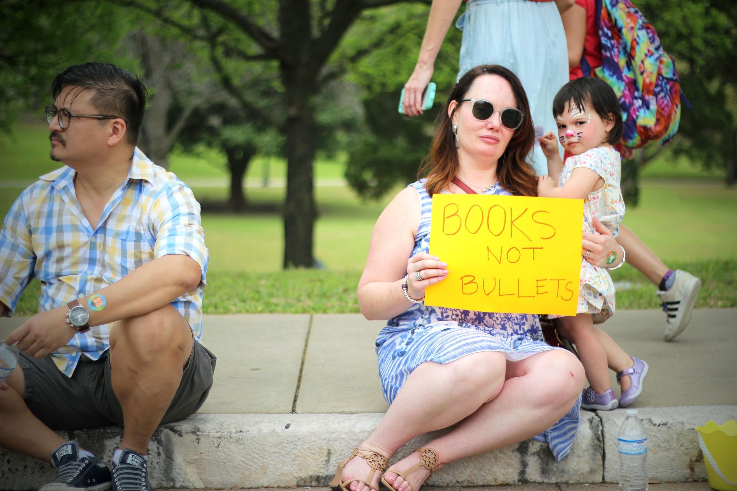   Sitting on a curb near the Capitol, a mother and her daughter show their sign.  