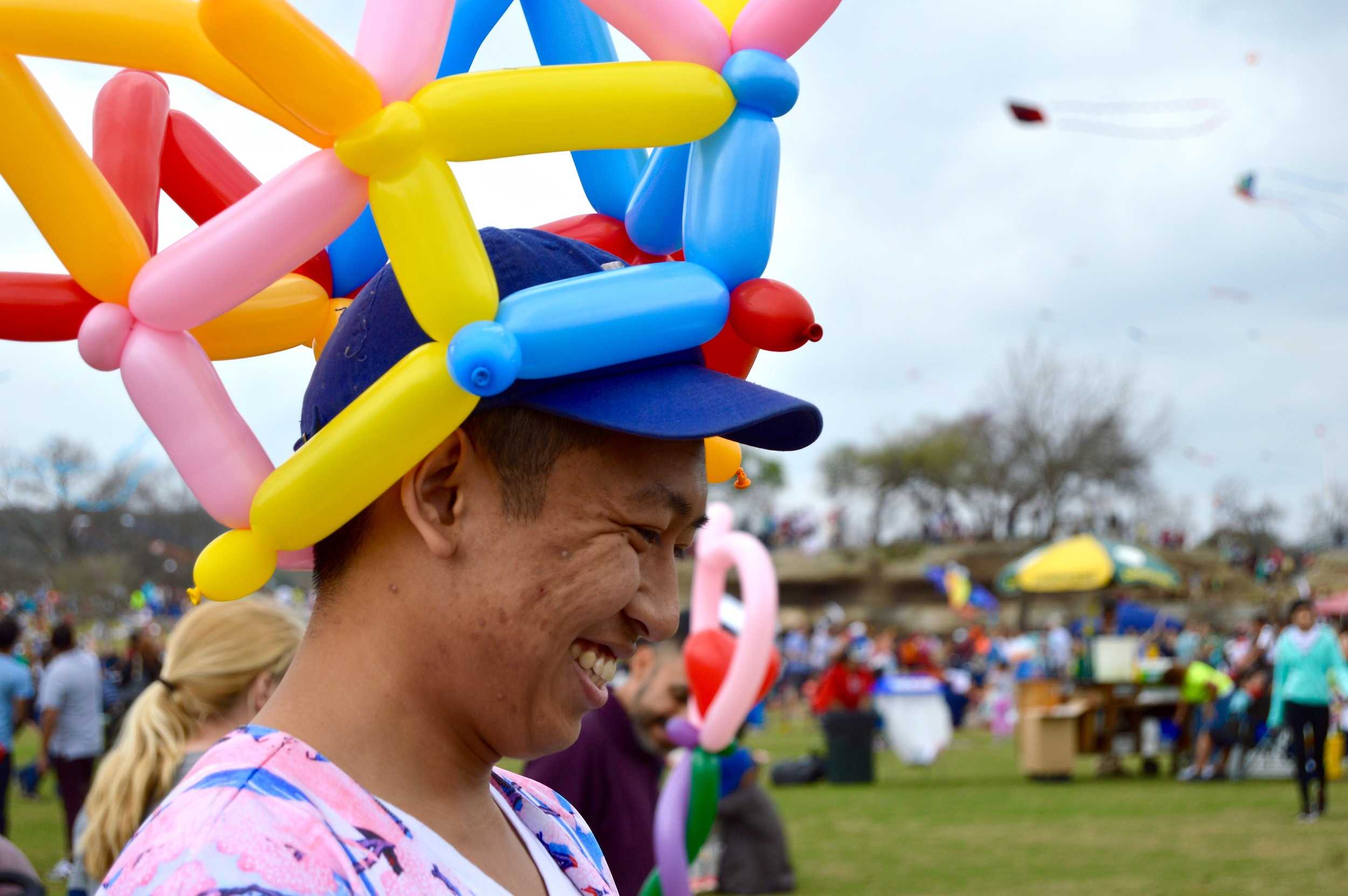  A festival volunteer makes balloon animals for children.&nbsp; 