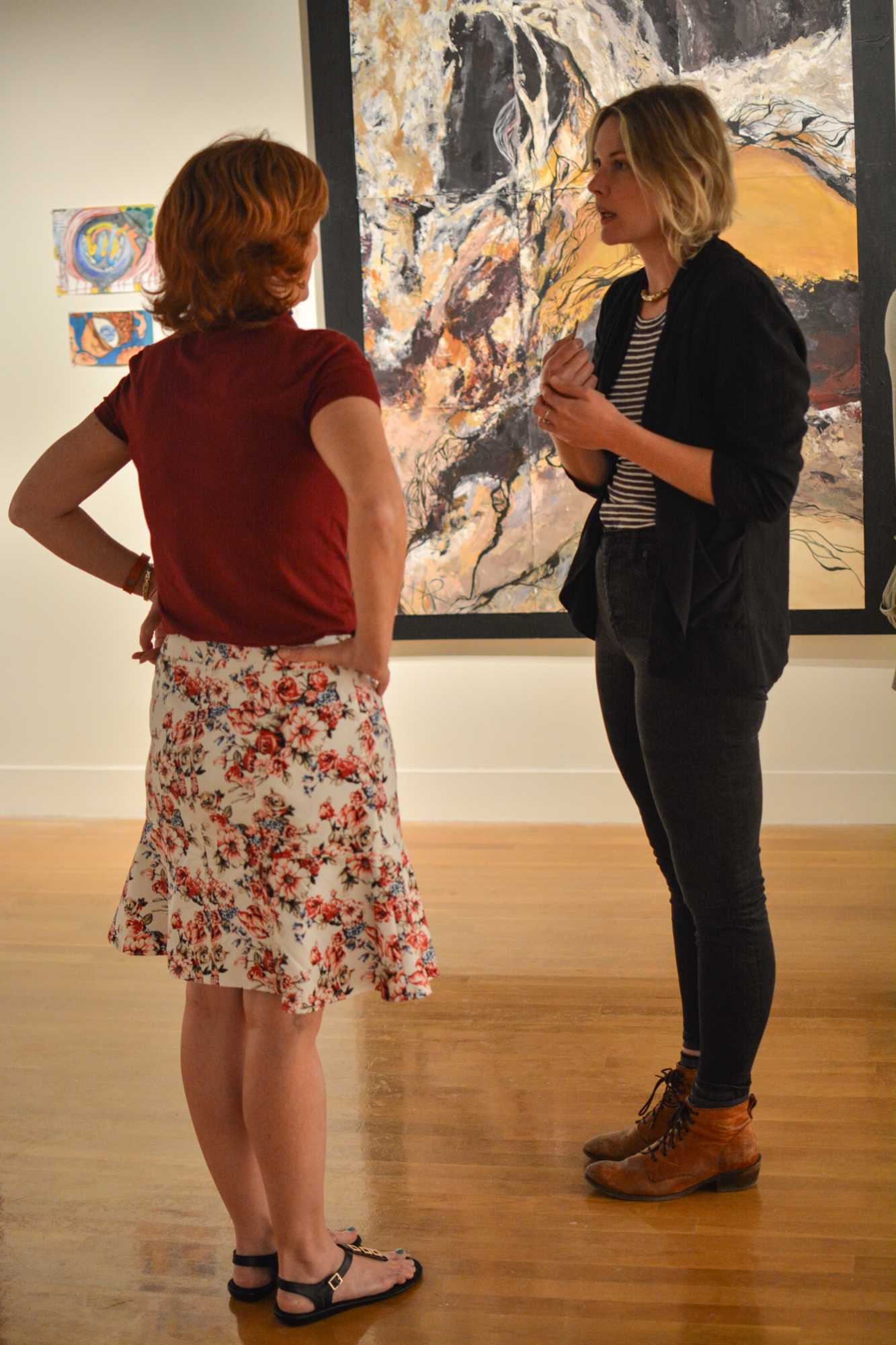   Two people who attended the Study Abroad Art Show in the Visual Art Center discuss the pieces on display.  