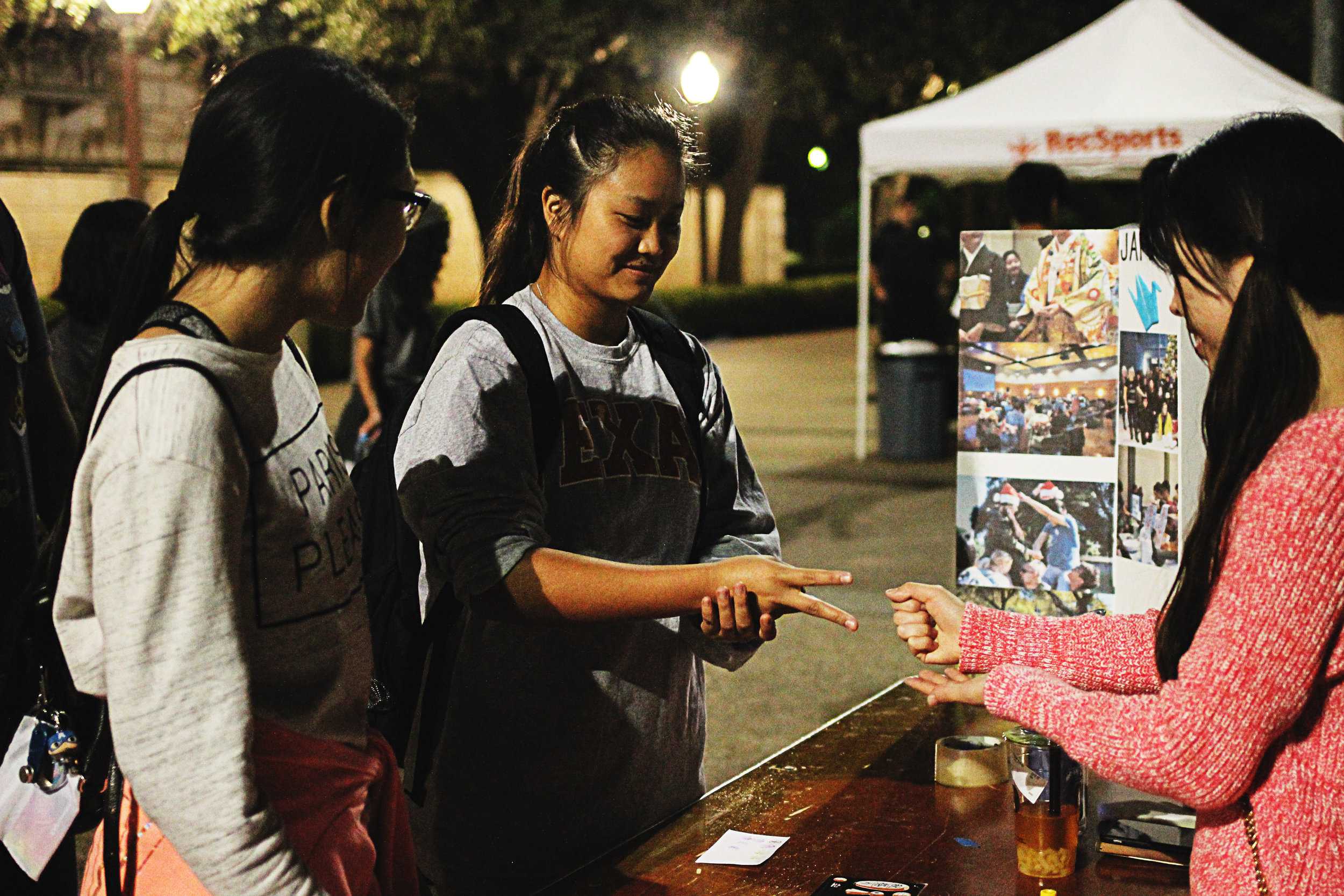   At one game booth, students play a game of rock-paper-scissors.     