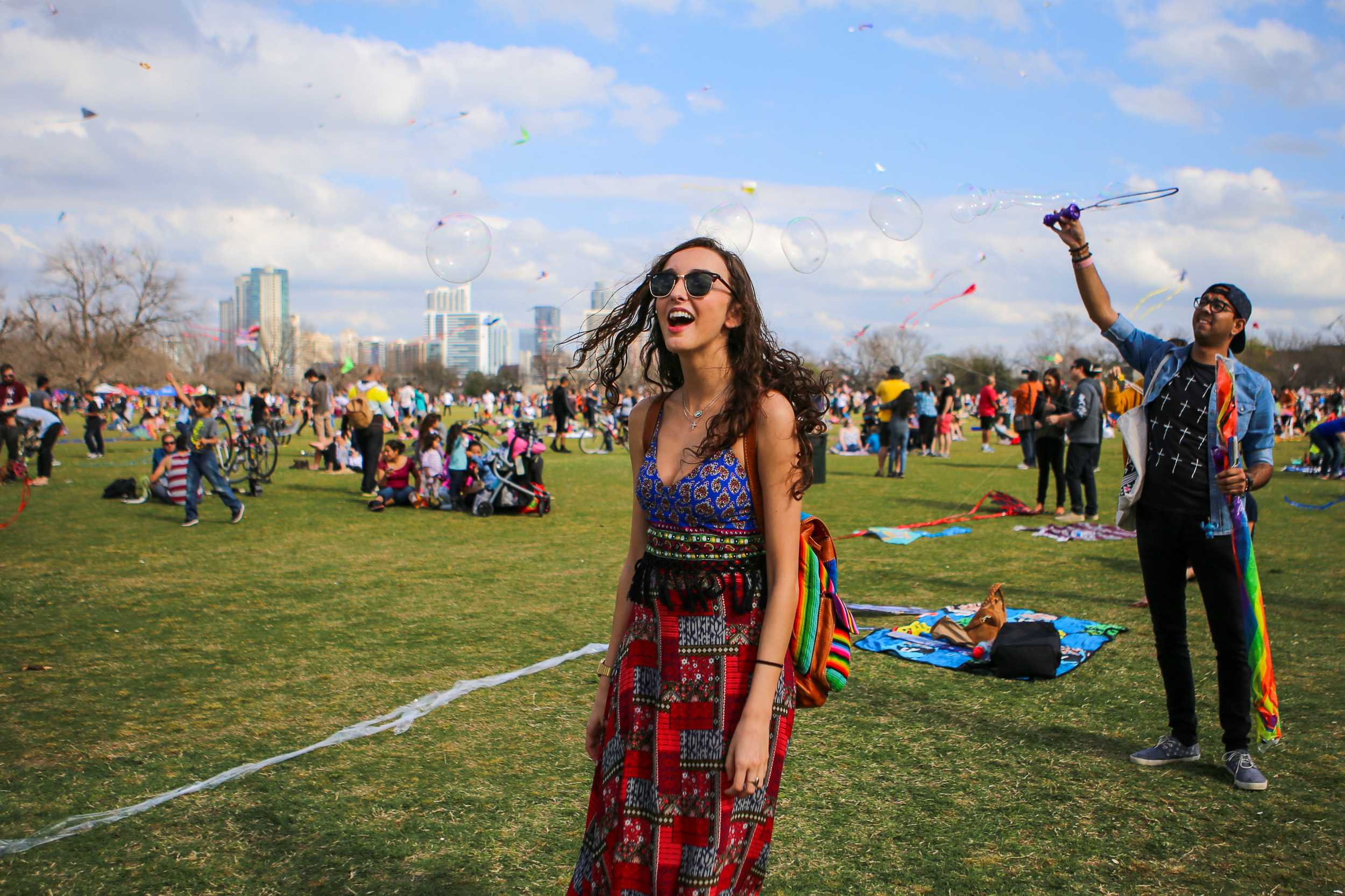  Senior Ashlyn Simon laughs as an attendee waves bubbles into the air. Simon says this was her first Kite Festival at Zilker park. 