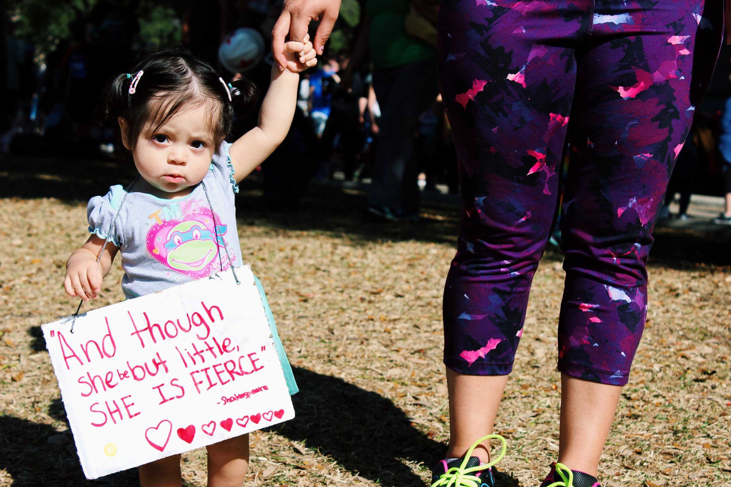   A young girl holds a sign that says, "'And though she be but little, she is fierce' -Shakespeare." Many young children joined their parents and families at the Women's March.     