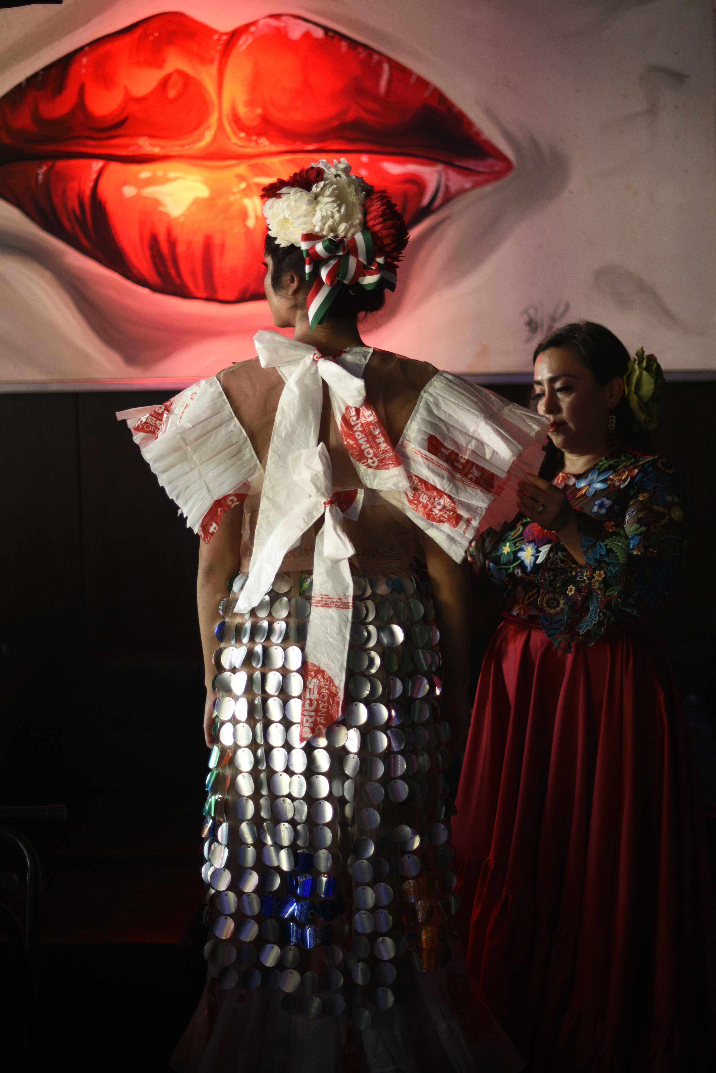   The designer put the finishing touches on an outfit inspired by Frida Kahlo backstage.  