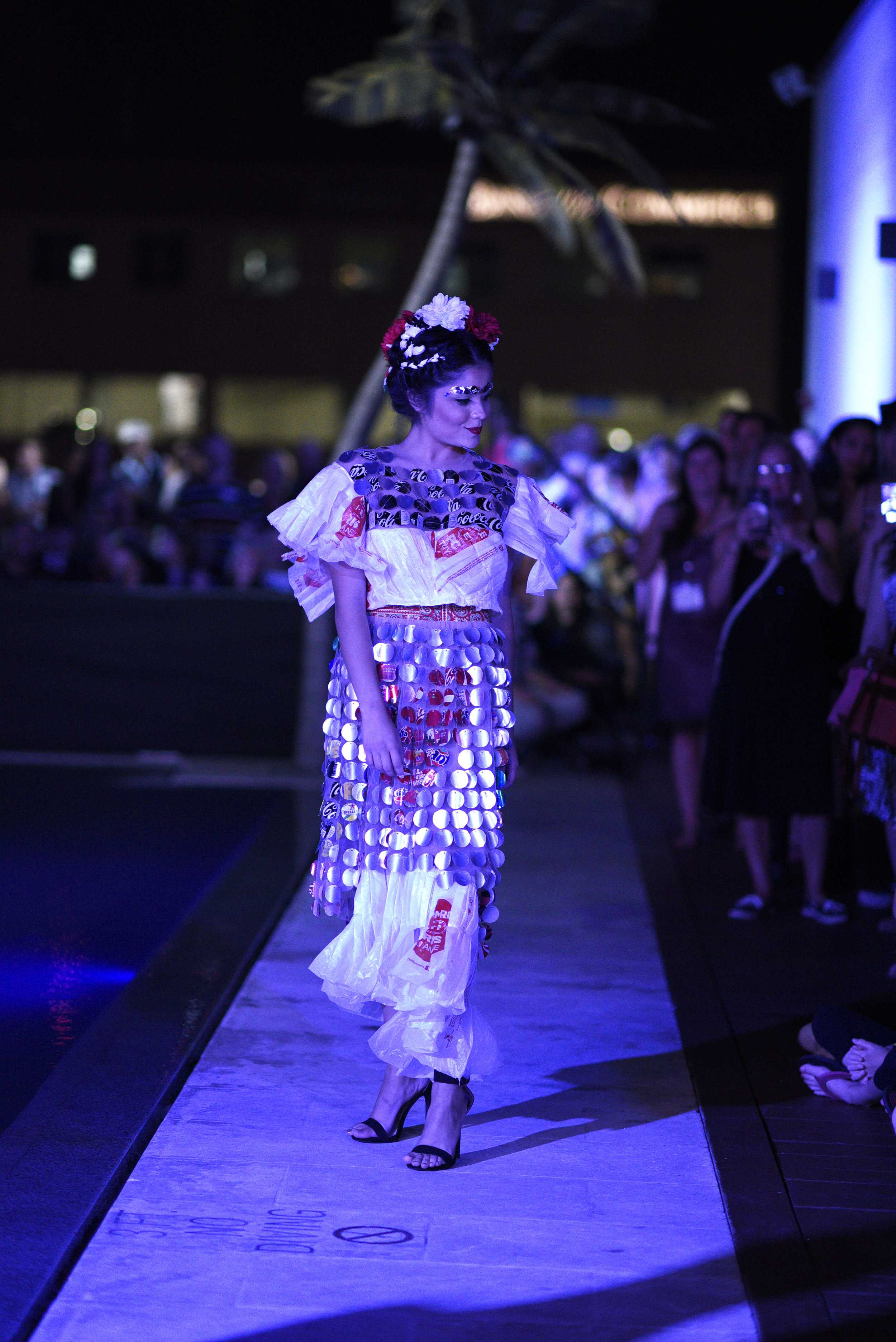   Model poses in front of audience while they take photos of her.  