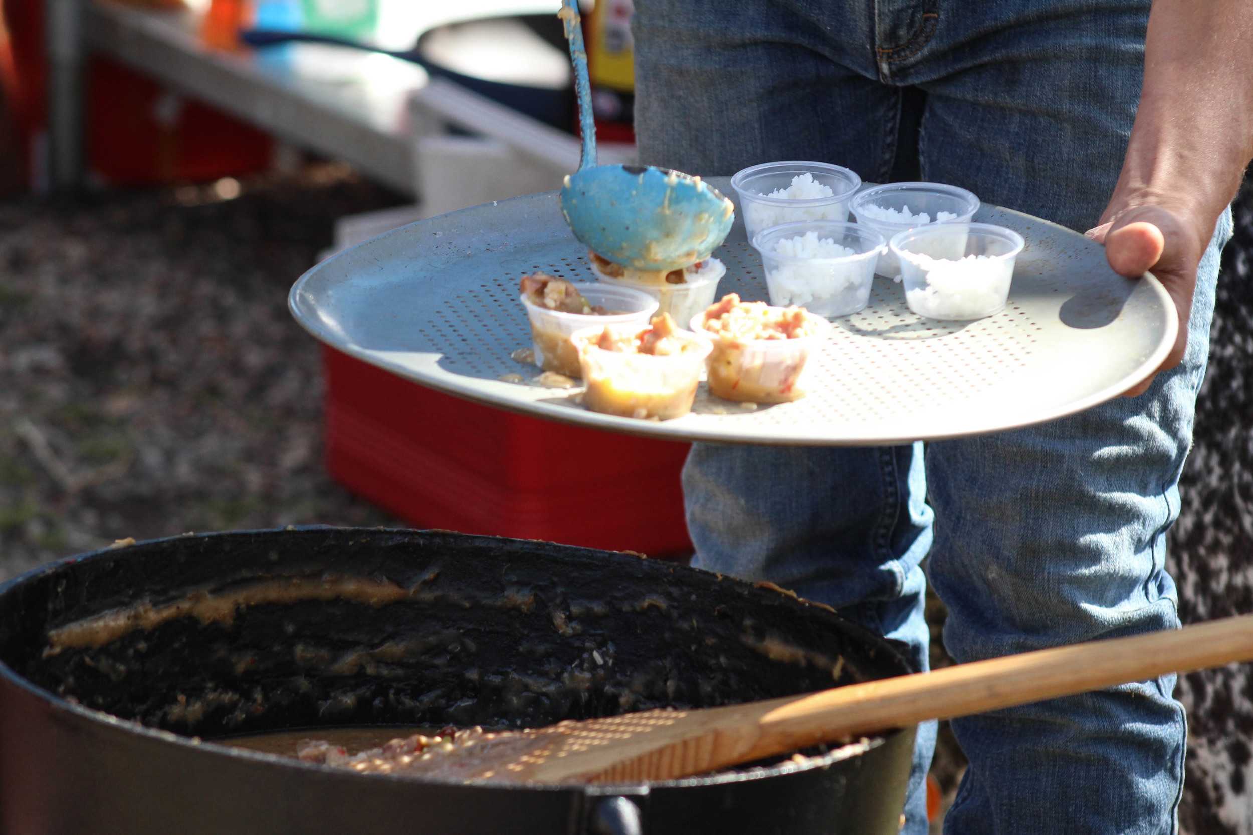   A fresh batch of gumbo is served over rice as more people taste and vote for their favorites.  