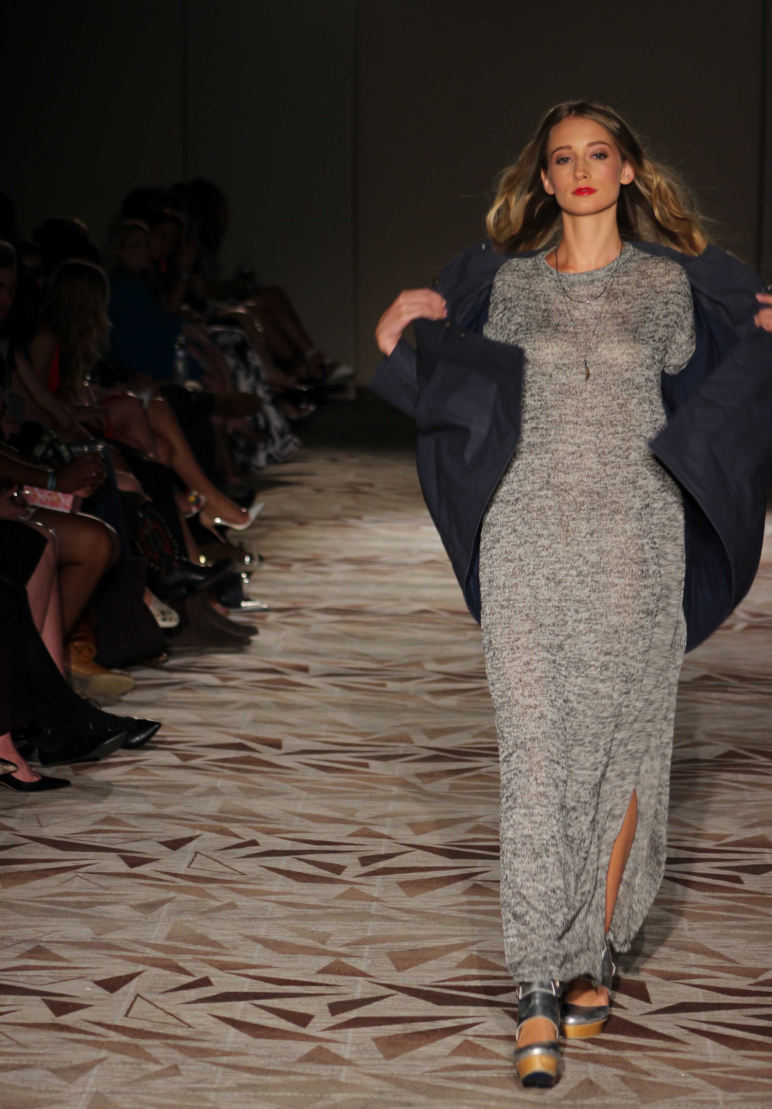   A model struts down the runway and shows off a grey knit dress from M.E. Shirley’s collection. Photo by Miranda Chiechi.  