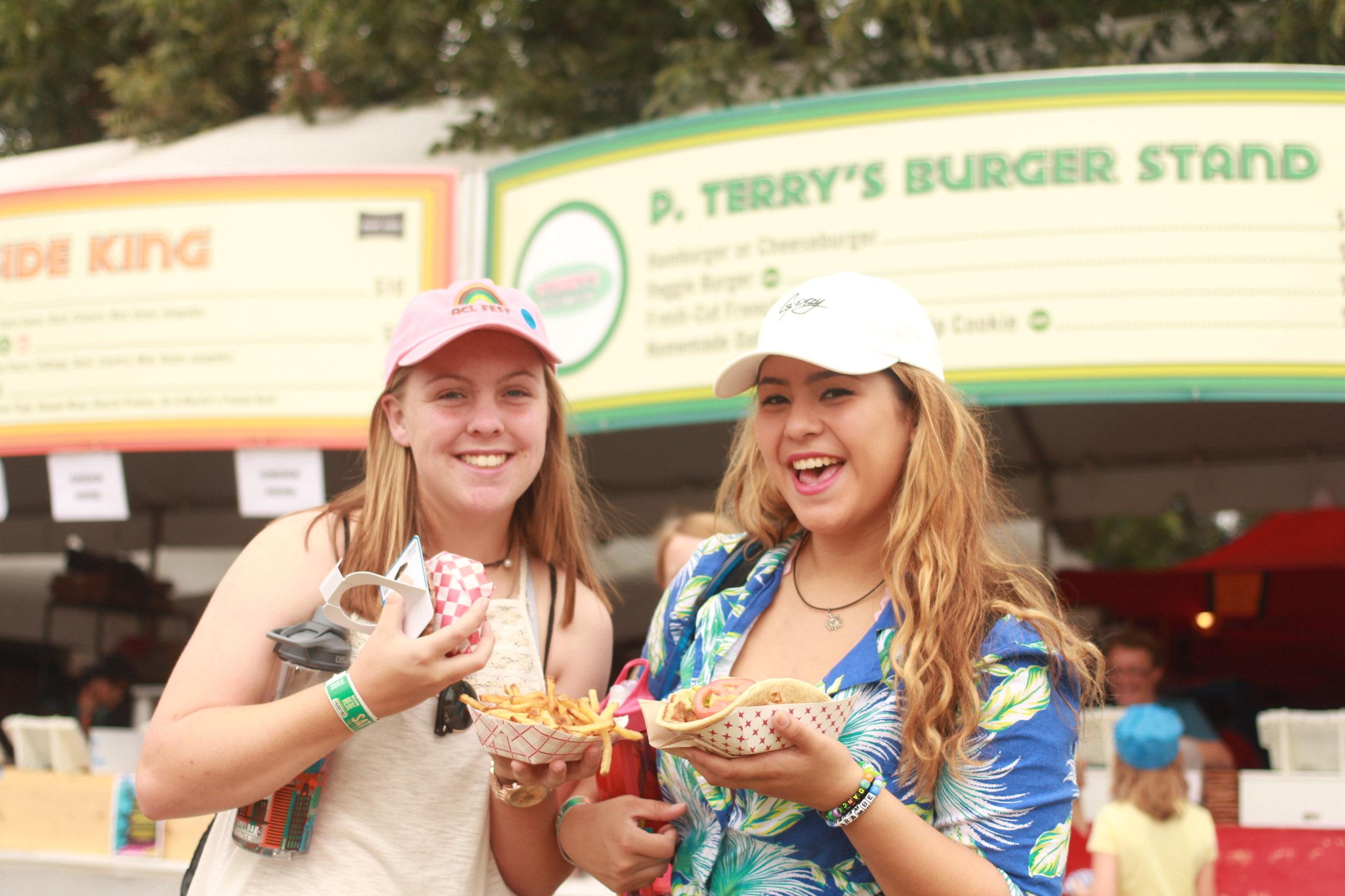   Two friends stand in front of P. Terry's pop-up burger stand.&nbsp;  