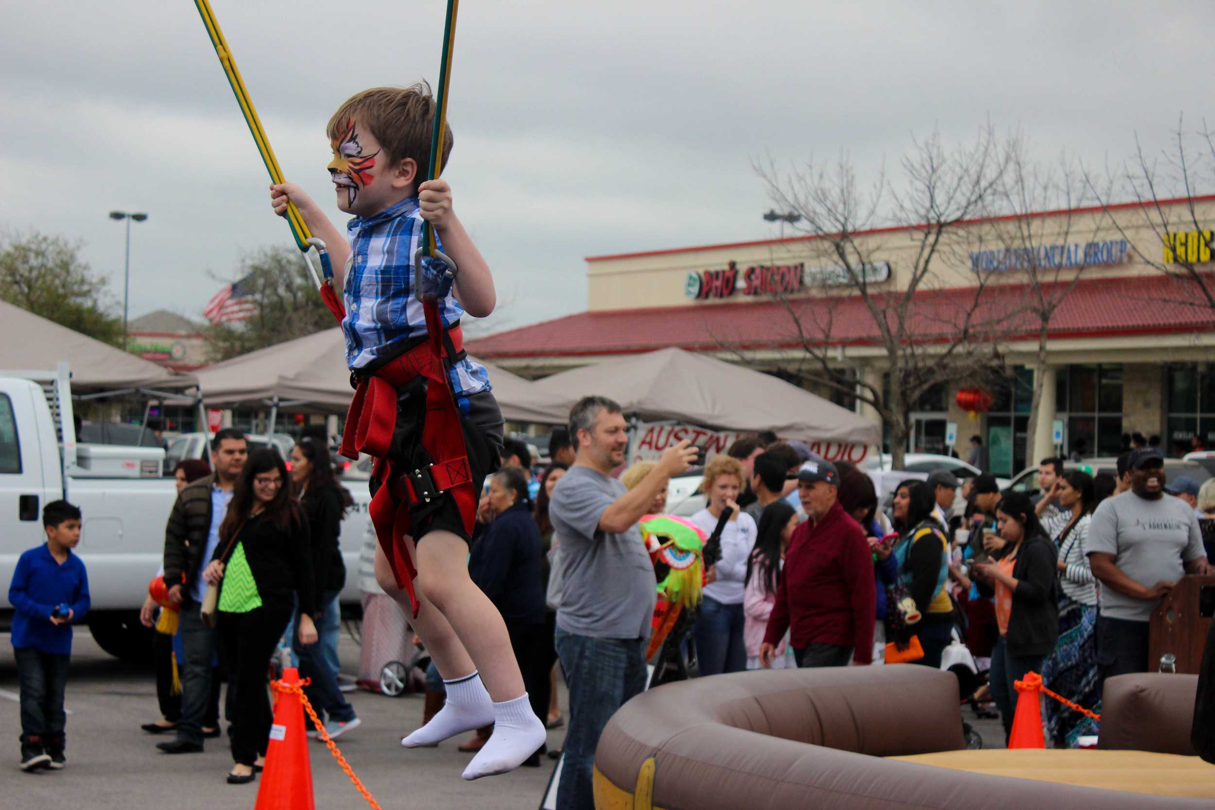  A face-painted boy bounces over the crowd's heads. 