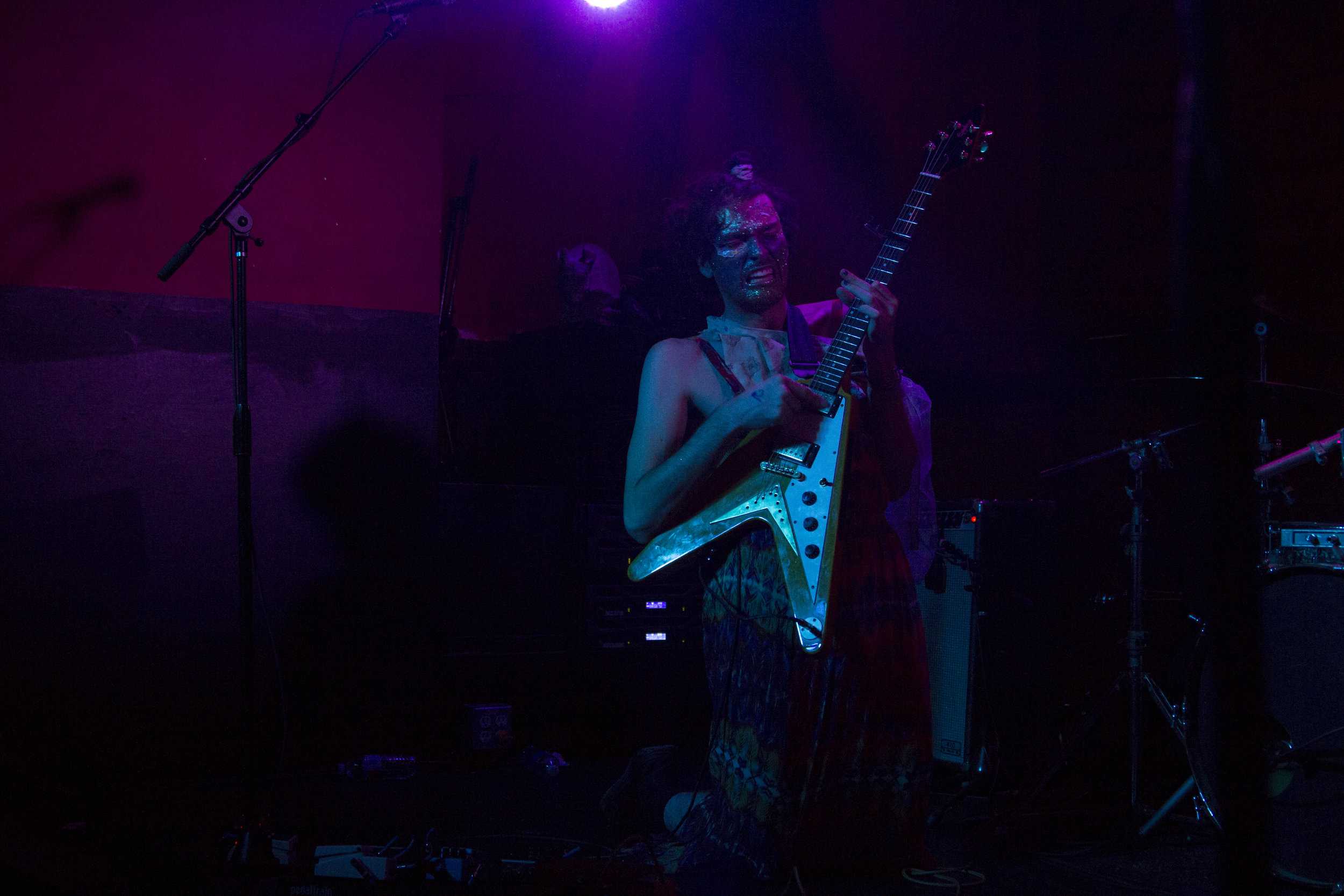   Lead guitarist Ben Hopkins performs with a face full of glitter and stickers.  