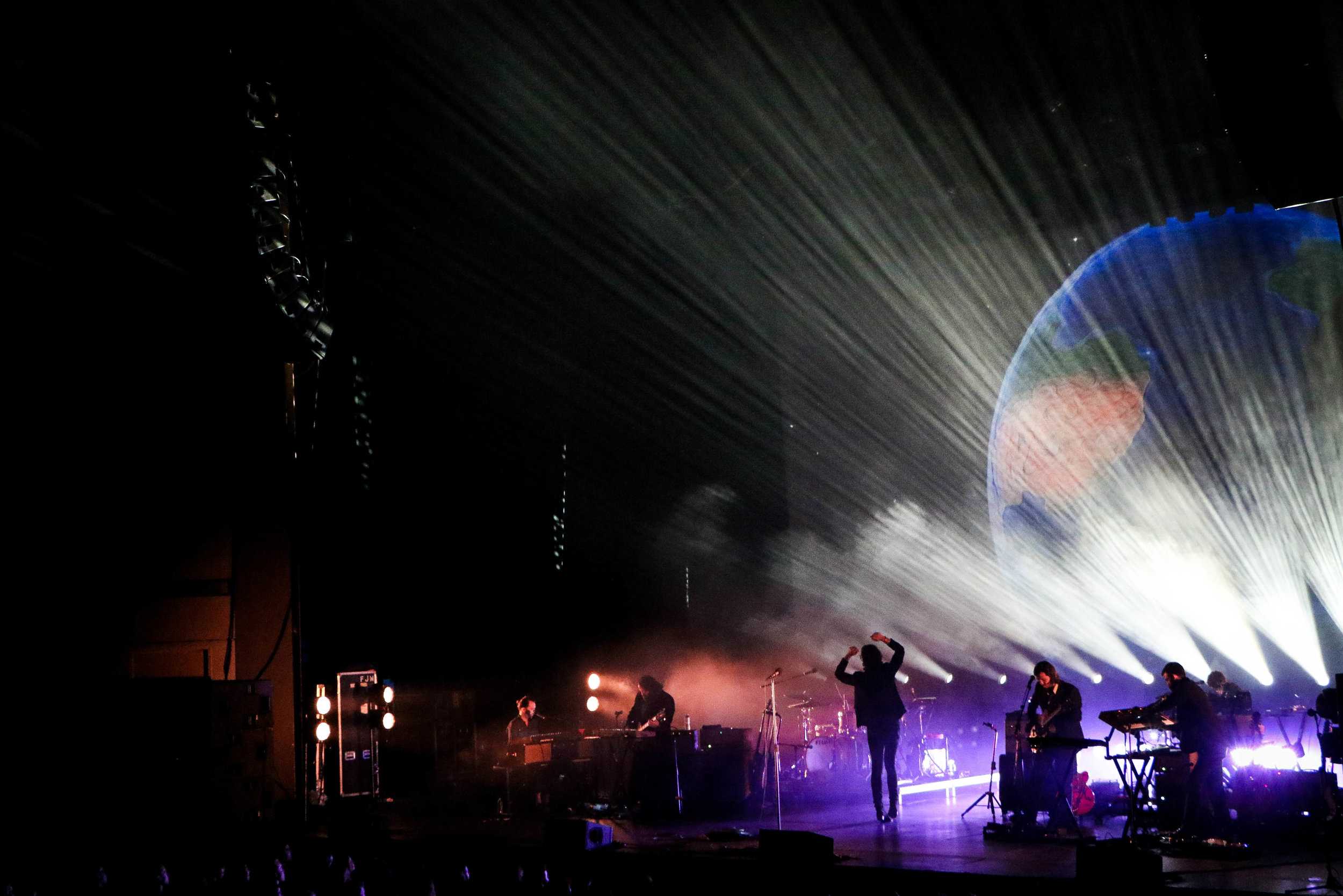   A dazzling light show and backdrop images accompany Father John Misty’s concert.  