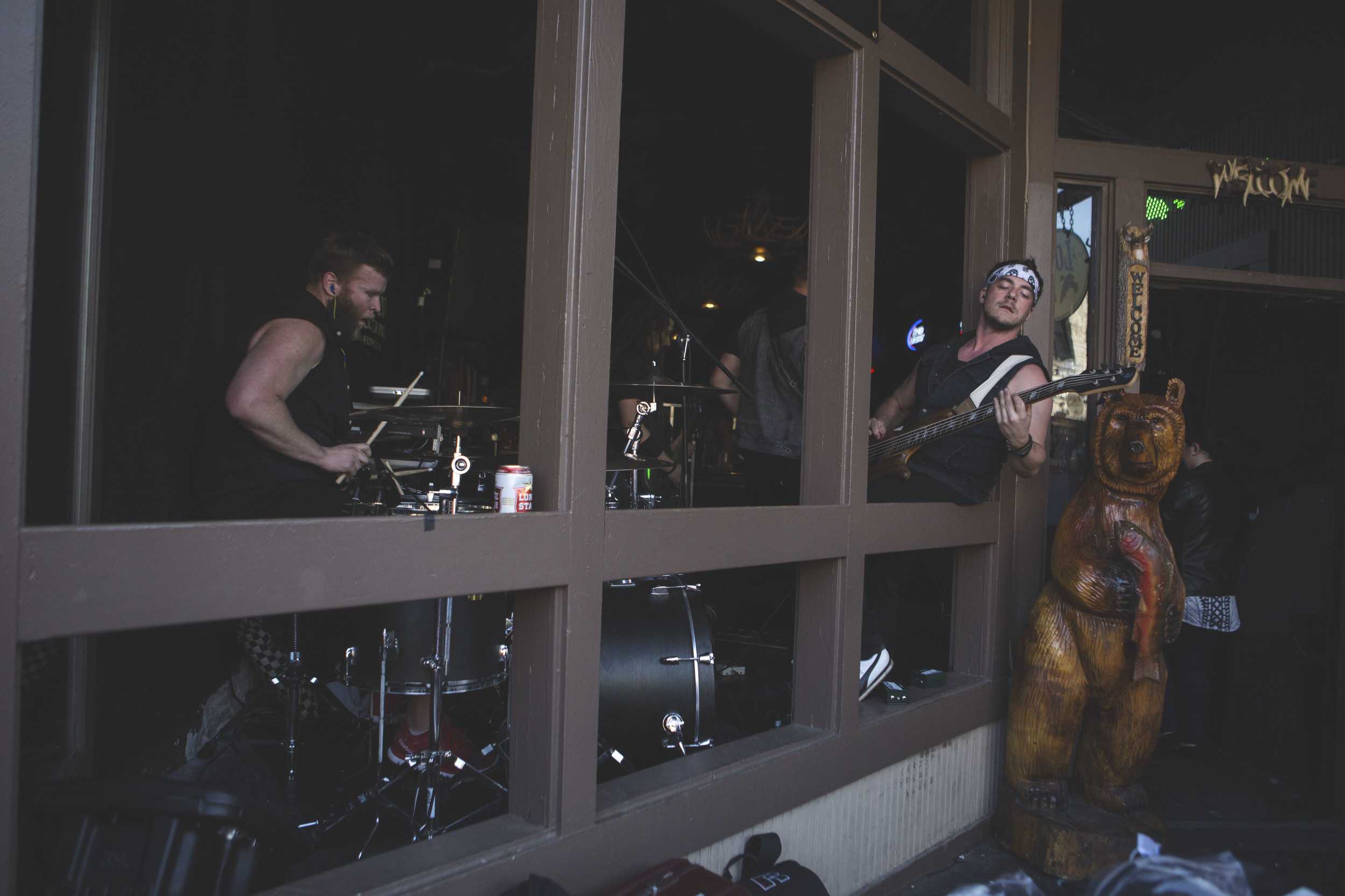  A band leans out of a venue window on Sixth Street on March 19. 