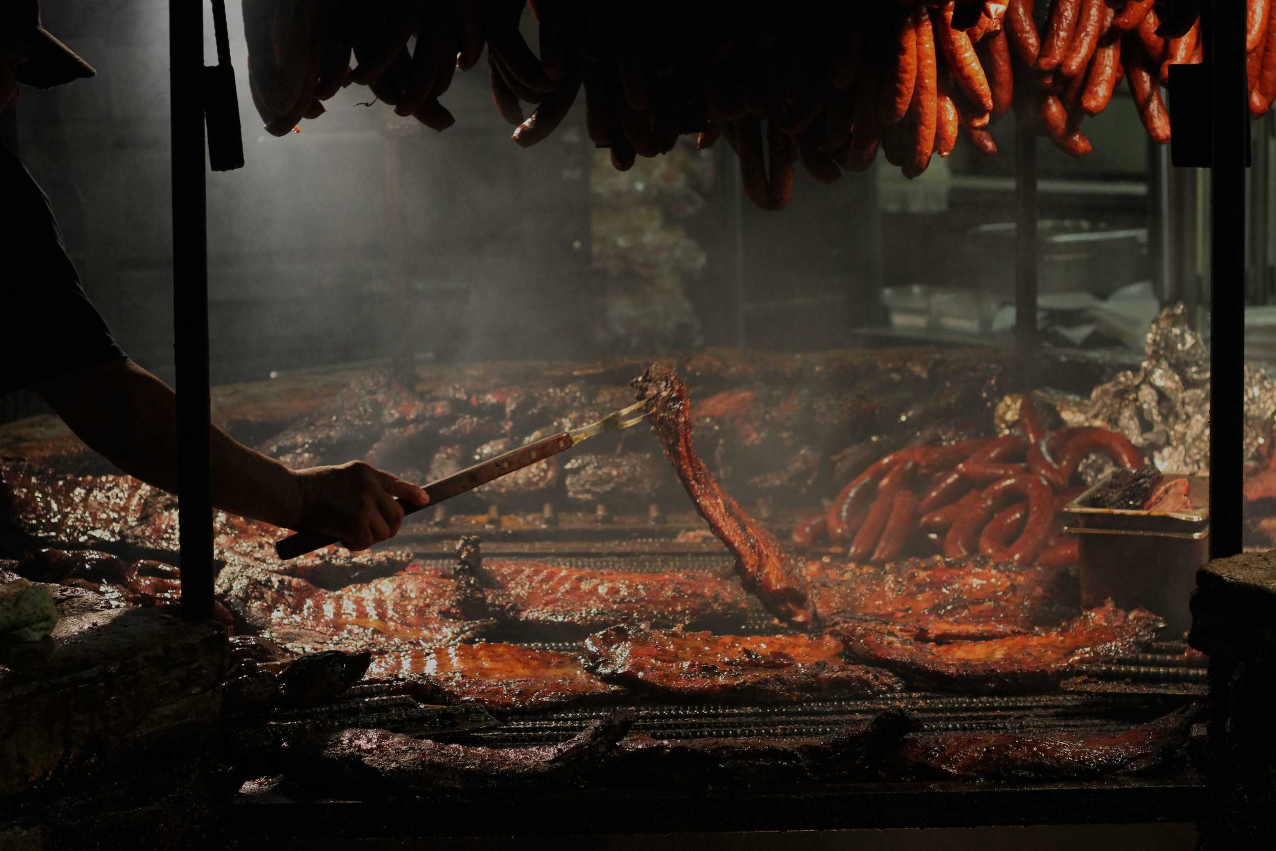   Barbecue masters at Salt Lick spend their Saturday afternoon hovering over their open barbecue pit, tending to the sea of meats to be served to hungry lunch-goers.    Photo by Jamie Medina     